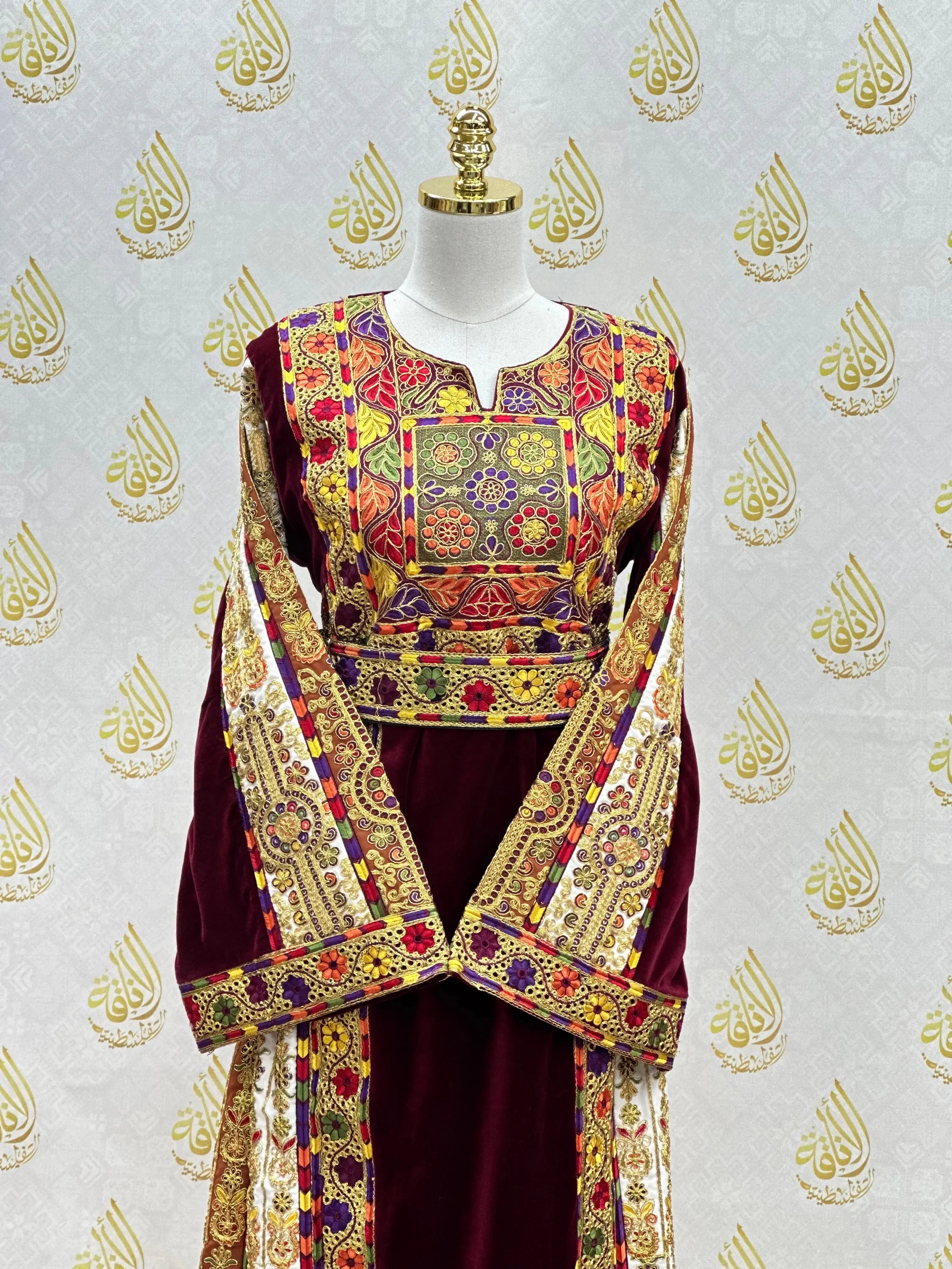 Velvet Palestinian dress with intricate colorful embroidery from Palestinian Elegance on a mannequin