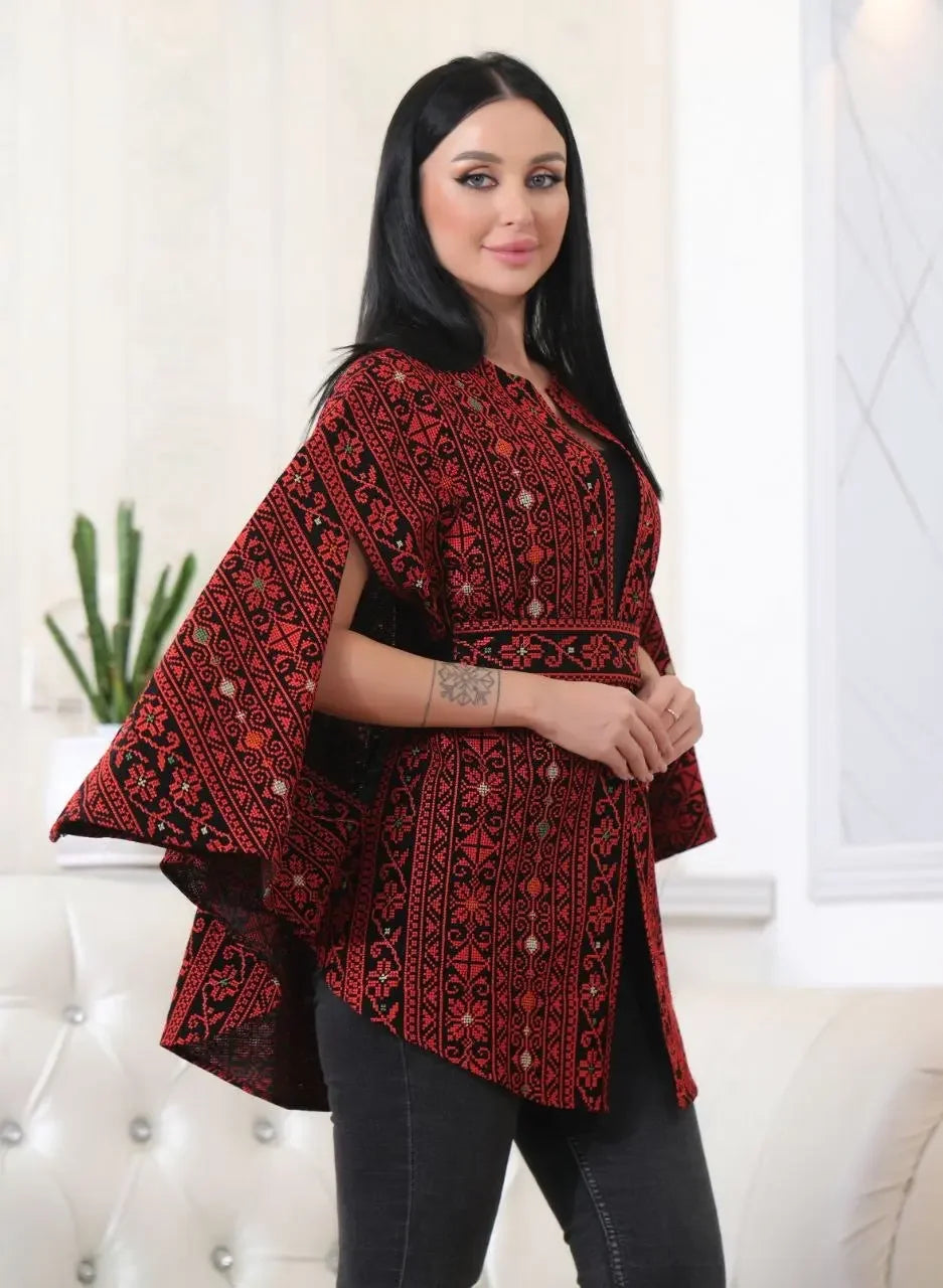 Palestinian Elegance embroidered cape jacket in red and black with traditional patterns worn by a woman
