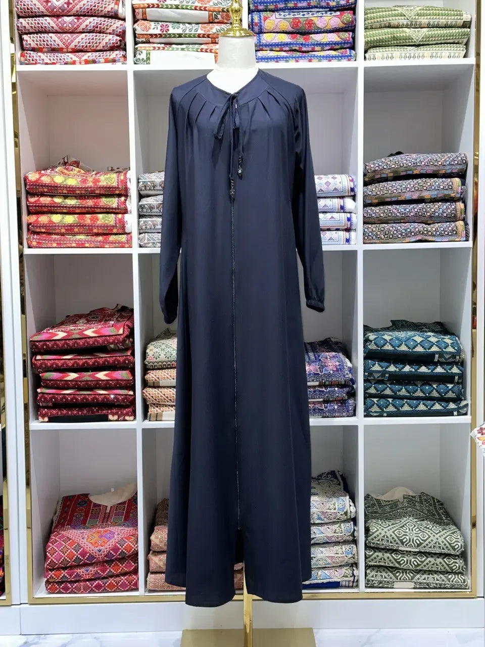 Black umra abaya for women displayed on a mannequin with long sleeves and front tie detail