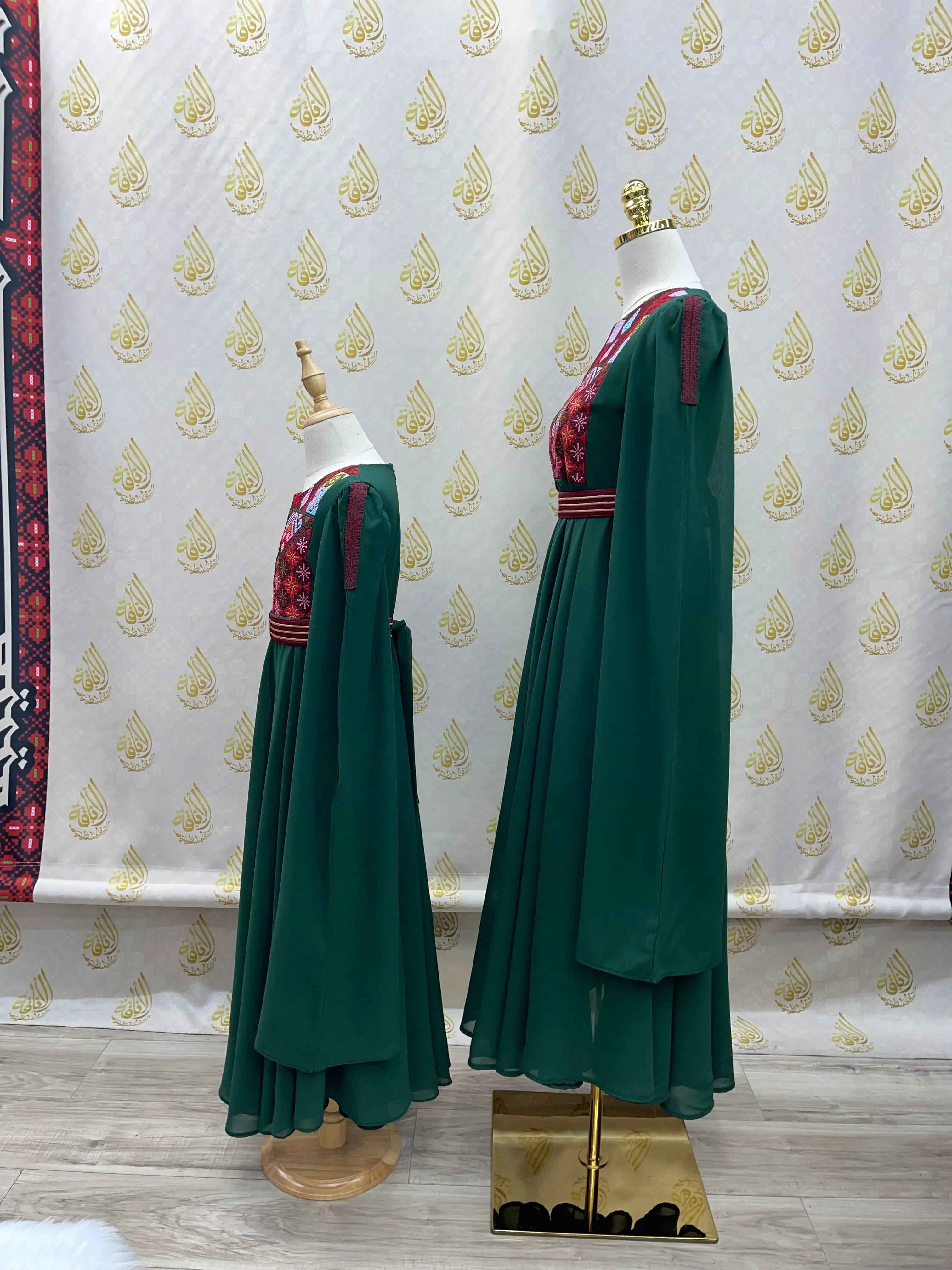 Palestinian girls embroidered dress in green with traditional red and black embroidery on mannequins