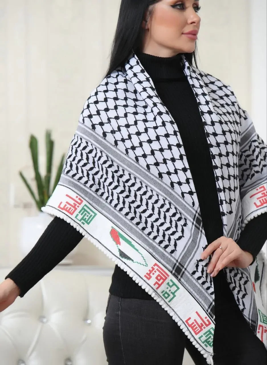Woman wearing black and white embroidered Palestinian kuffiyeh with traditional patterns and colorful accents