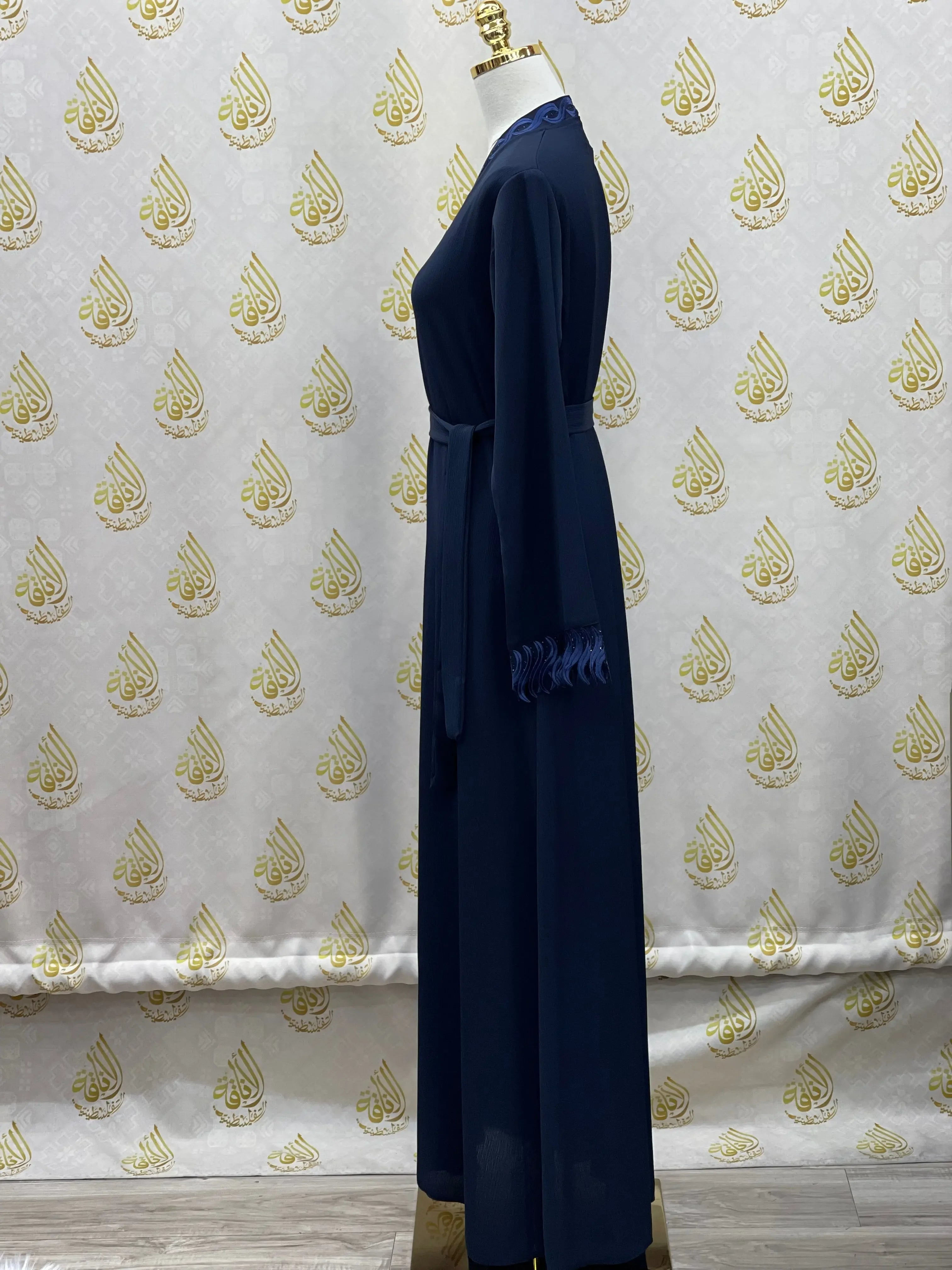 Elegant embroidered abaya in navy blue from Palestinian Elegance displayed on a mannequin