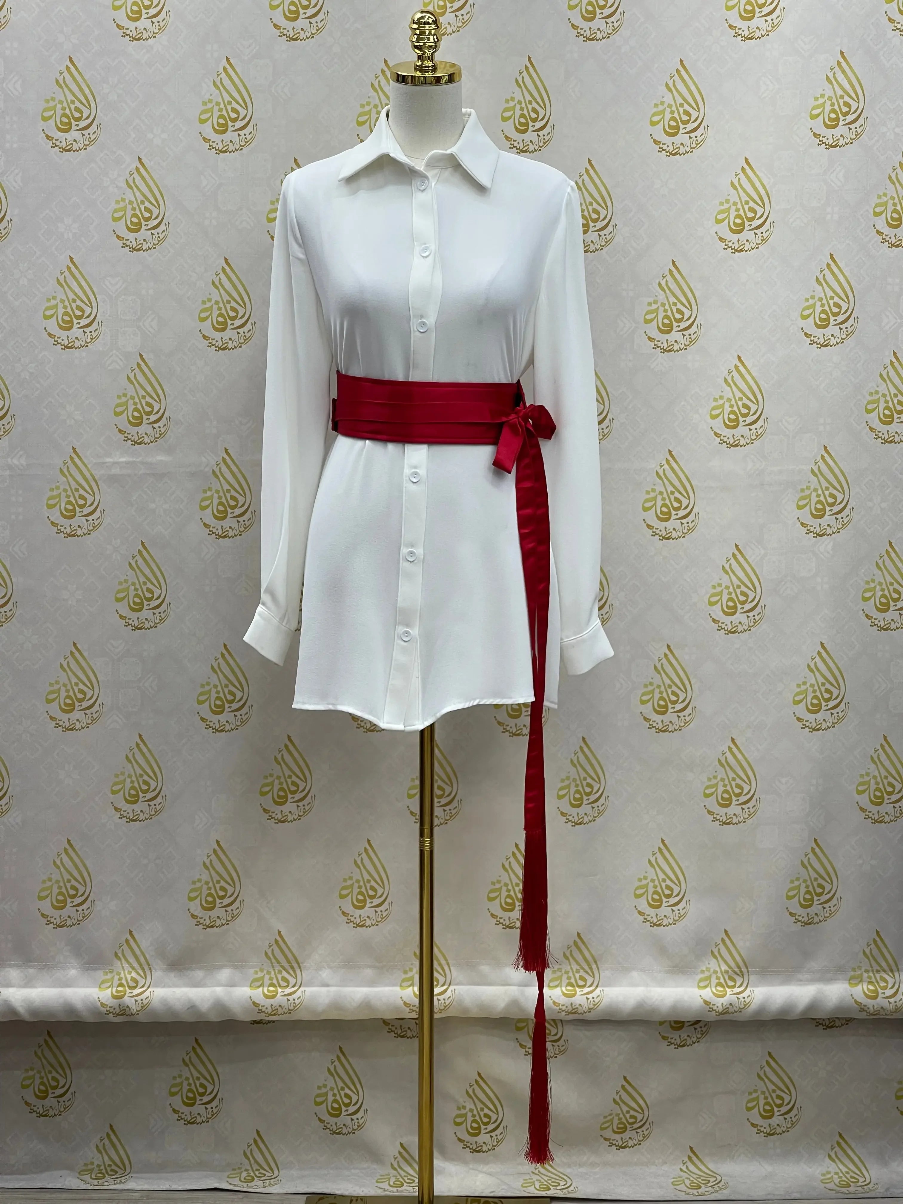 Palestinian Elegance luxury satin belt for dresses in deep red tied around white shirt dress on mannequin