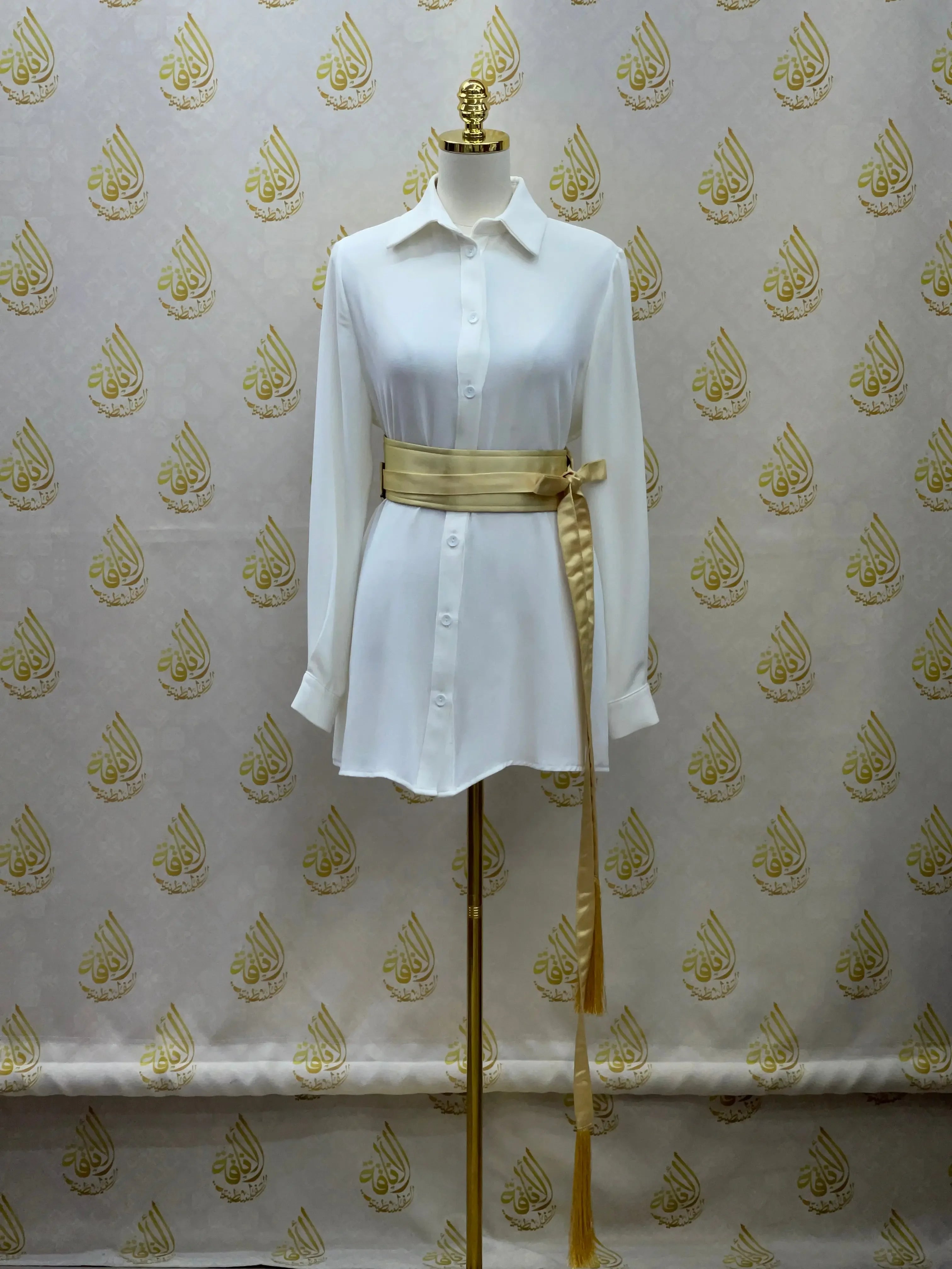 Luxury satin belt for dresses in gold tied around white shirt dress on mannequin