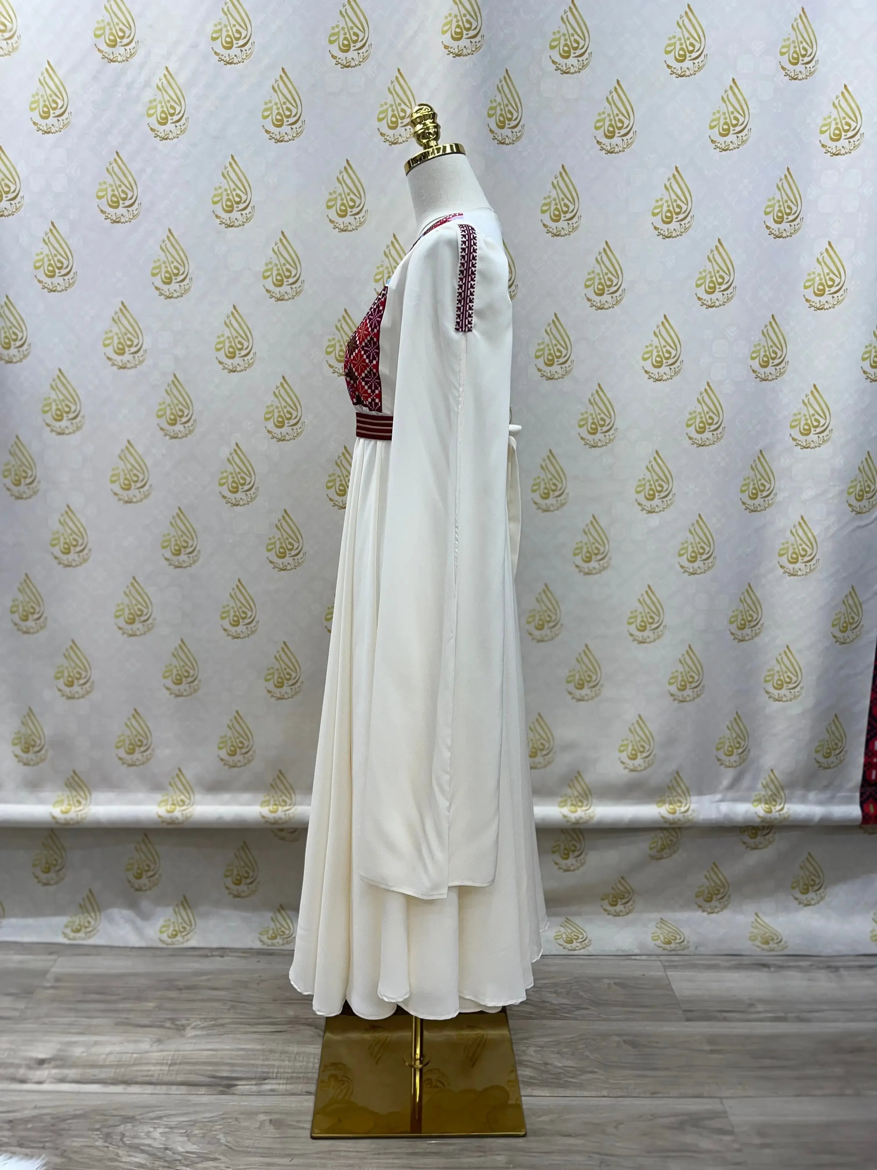 Palestinian girls embroidered dress with white flowing fabric and traditional red embroidery on bodice and sleeves