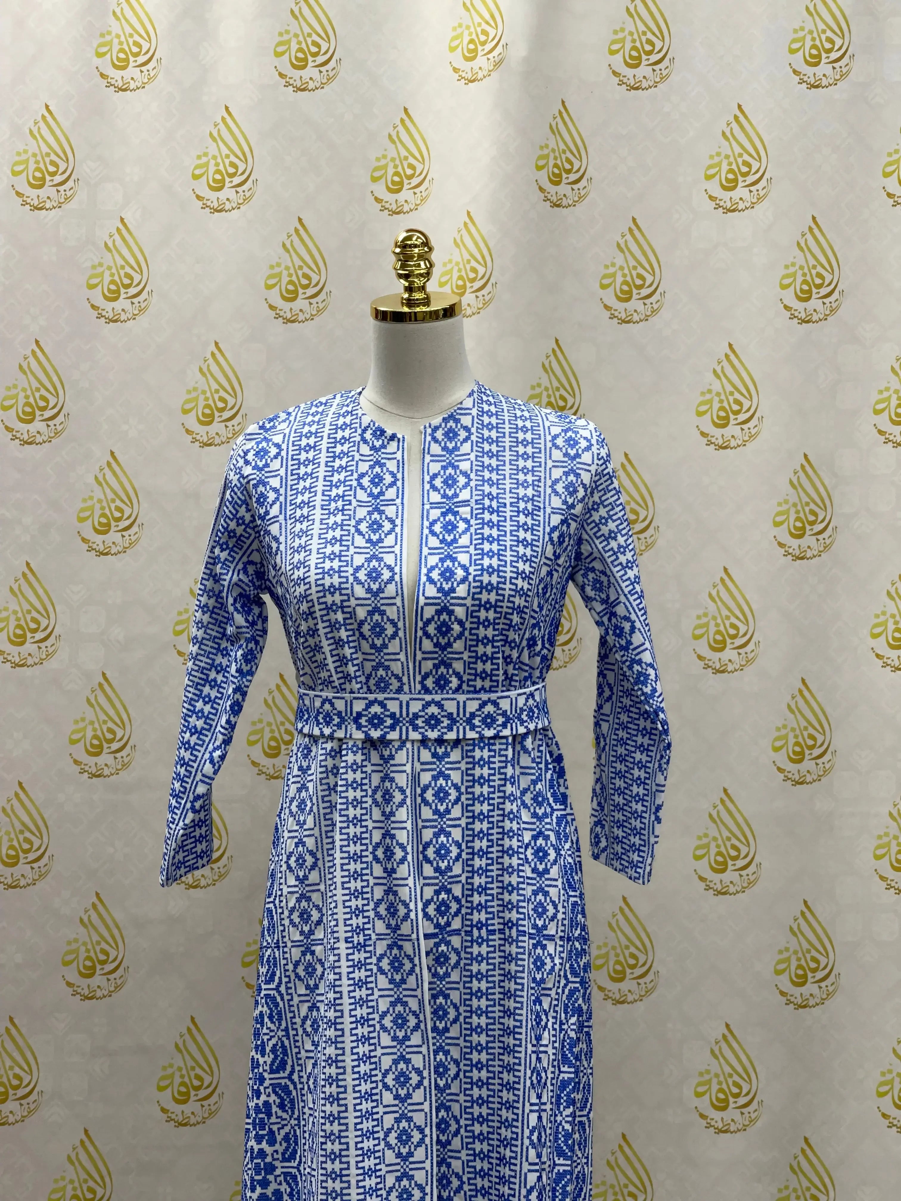 Blue and white embroidered cardigan for kids with traditional Palestinian patterns on mannequin