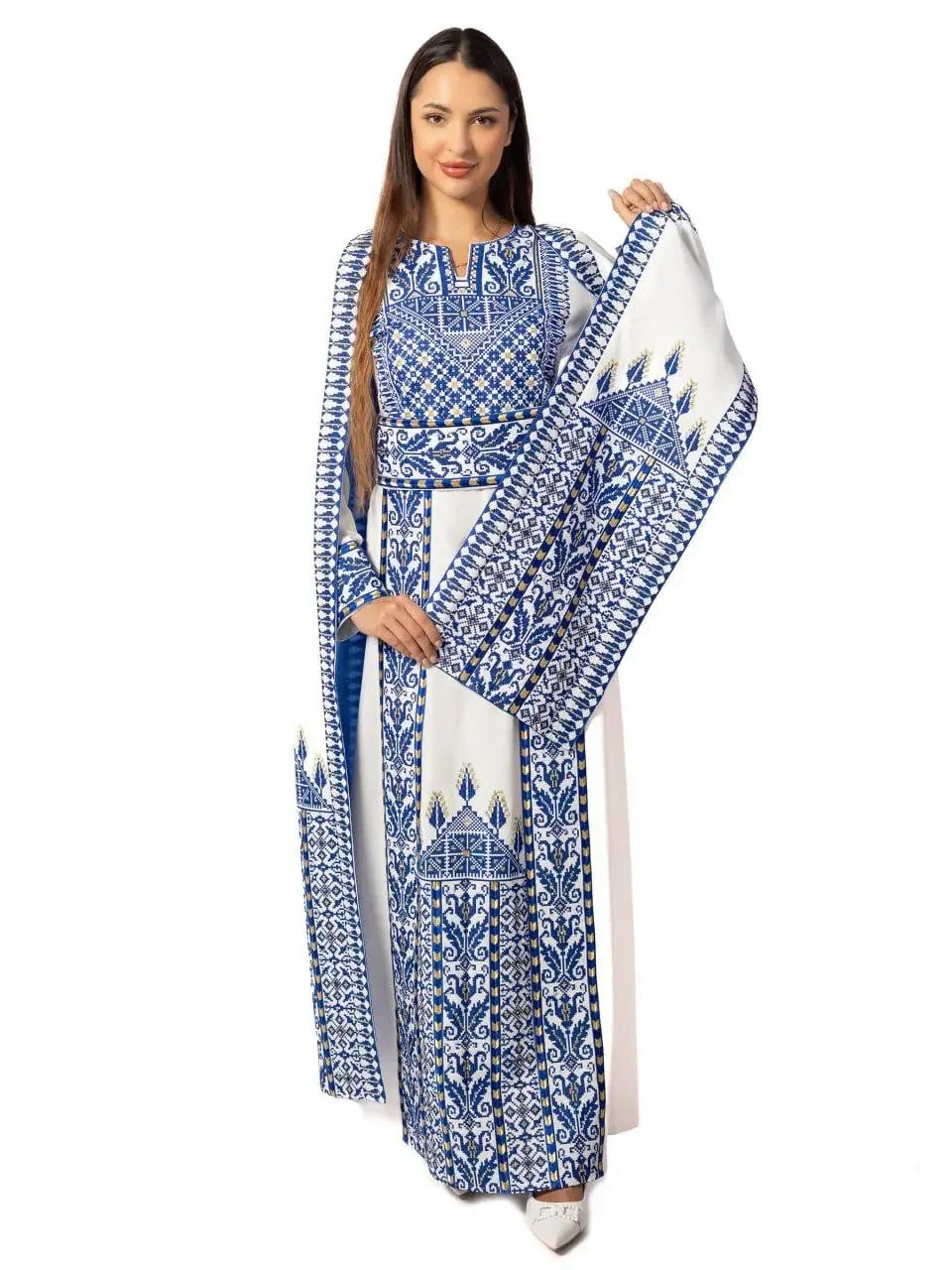 Woman wearing a blue and white embroidered Palestinian thobe dress with traditional intricate patterns