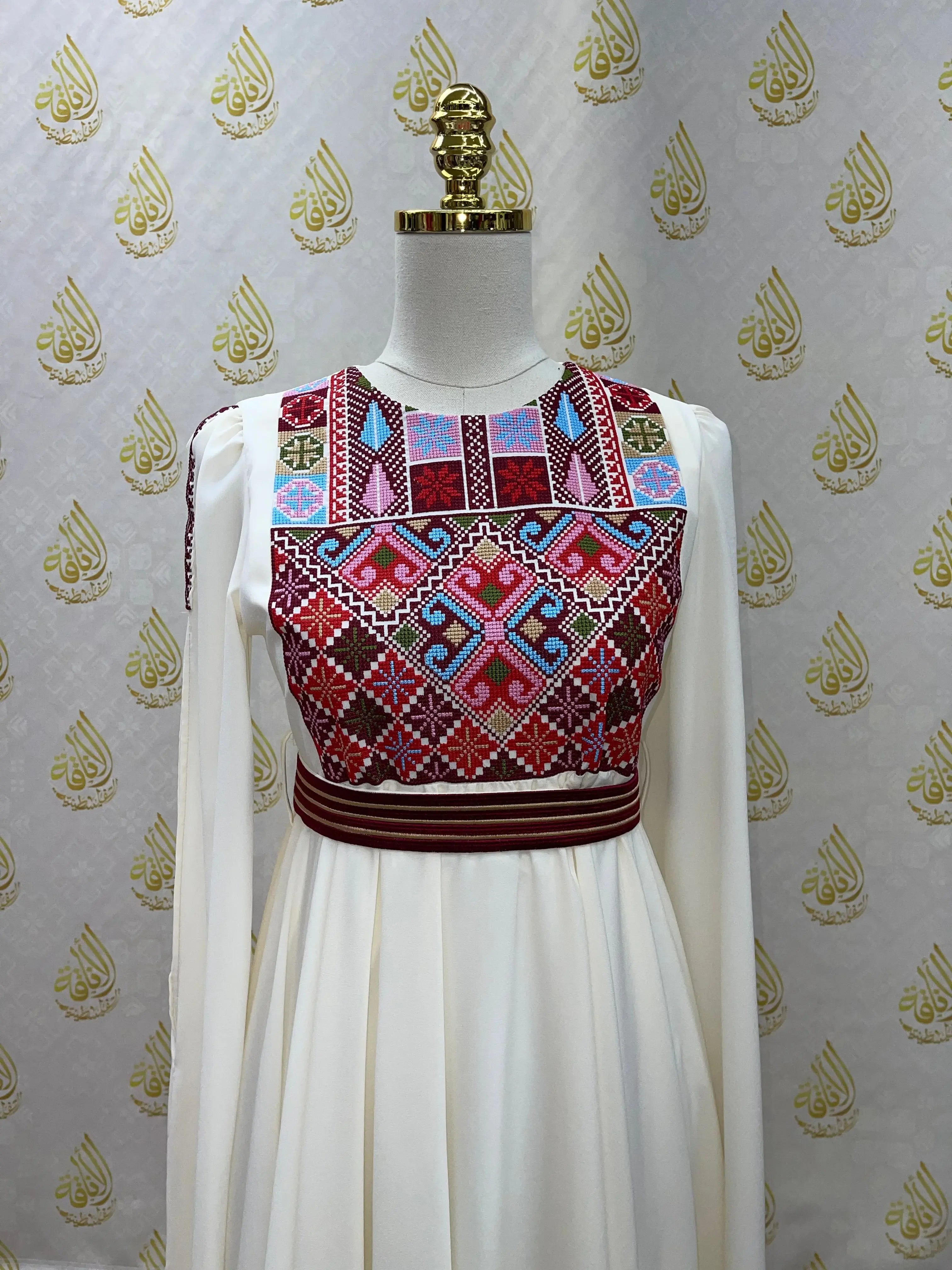 Palestinian girls embroidered dress with colorful traditional patterns on white fabric by Palestinian Elegance