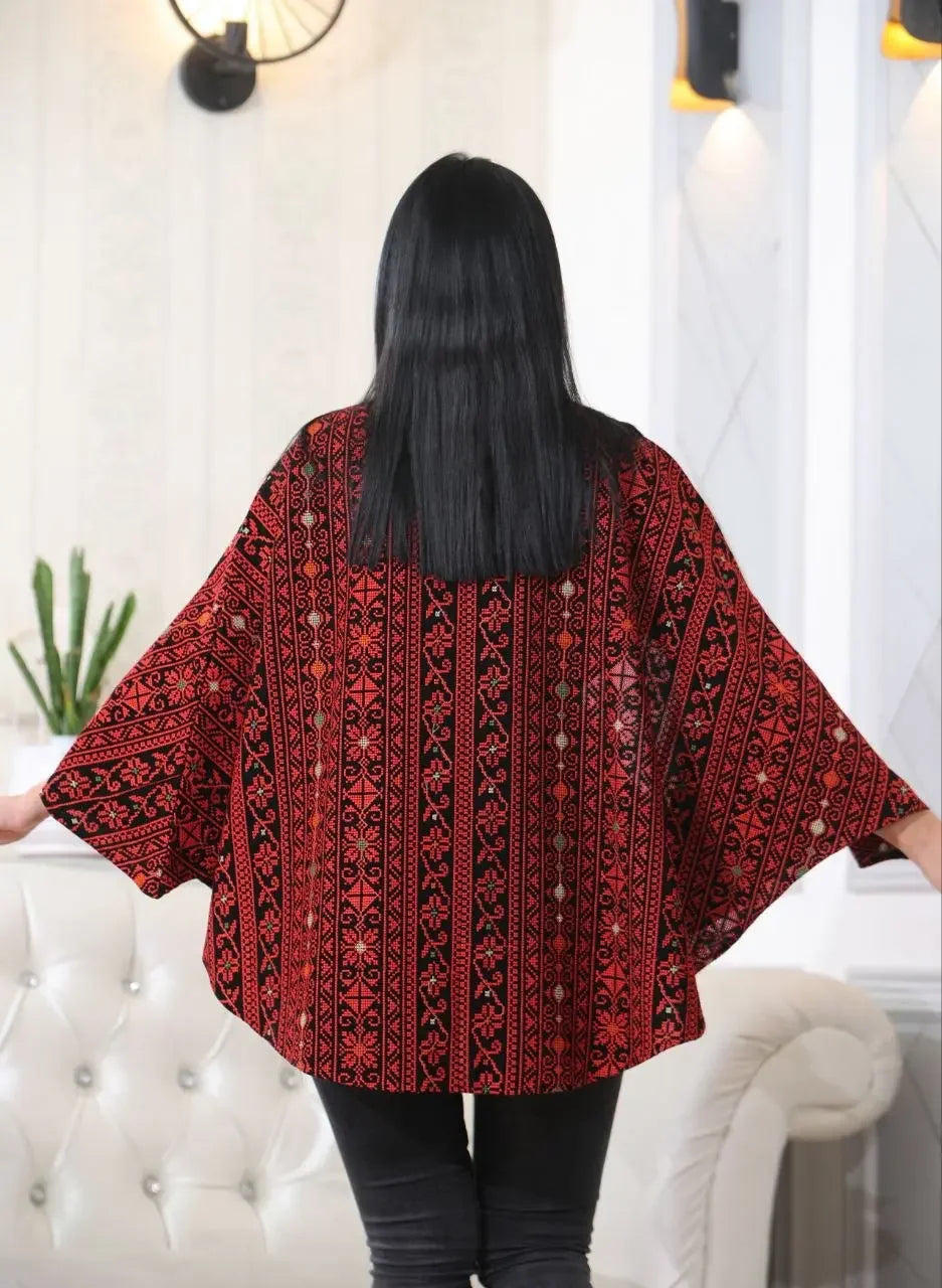 Palestinian Elegance embroidered cape jacket in red and black geometric patterns worn by model from the back