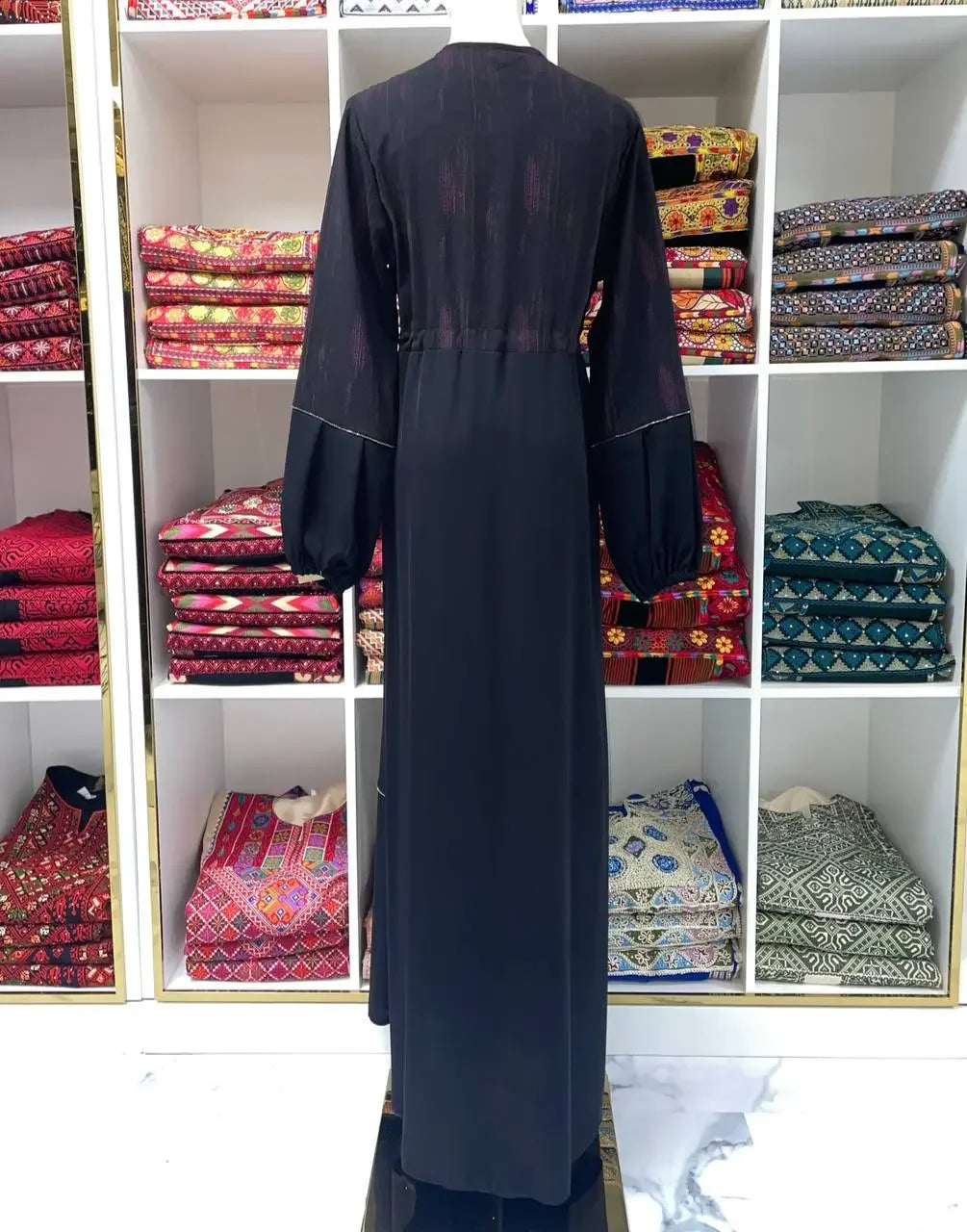 Black modern abaya dress for women with long sleeves displayed on a mannequin by Palestinian Elegance