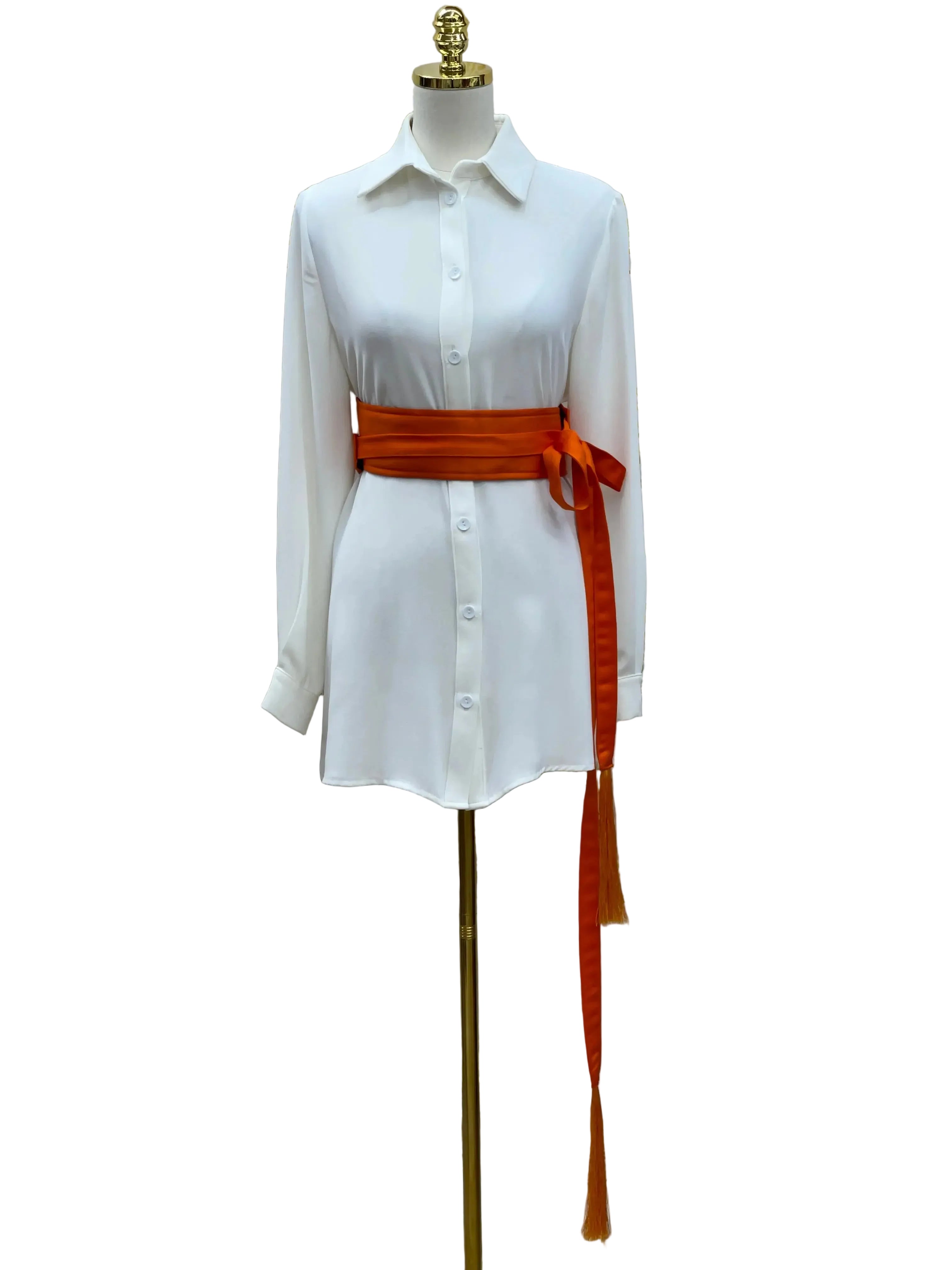 Luxury satin belt for dresses in rich orange wrapped around white button-down shirt on mannequin