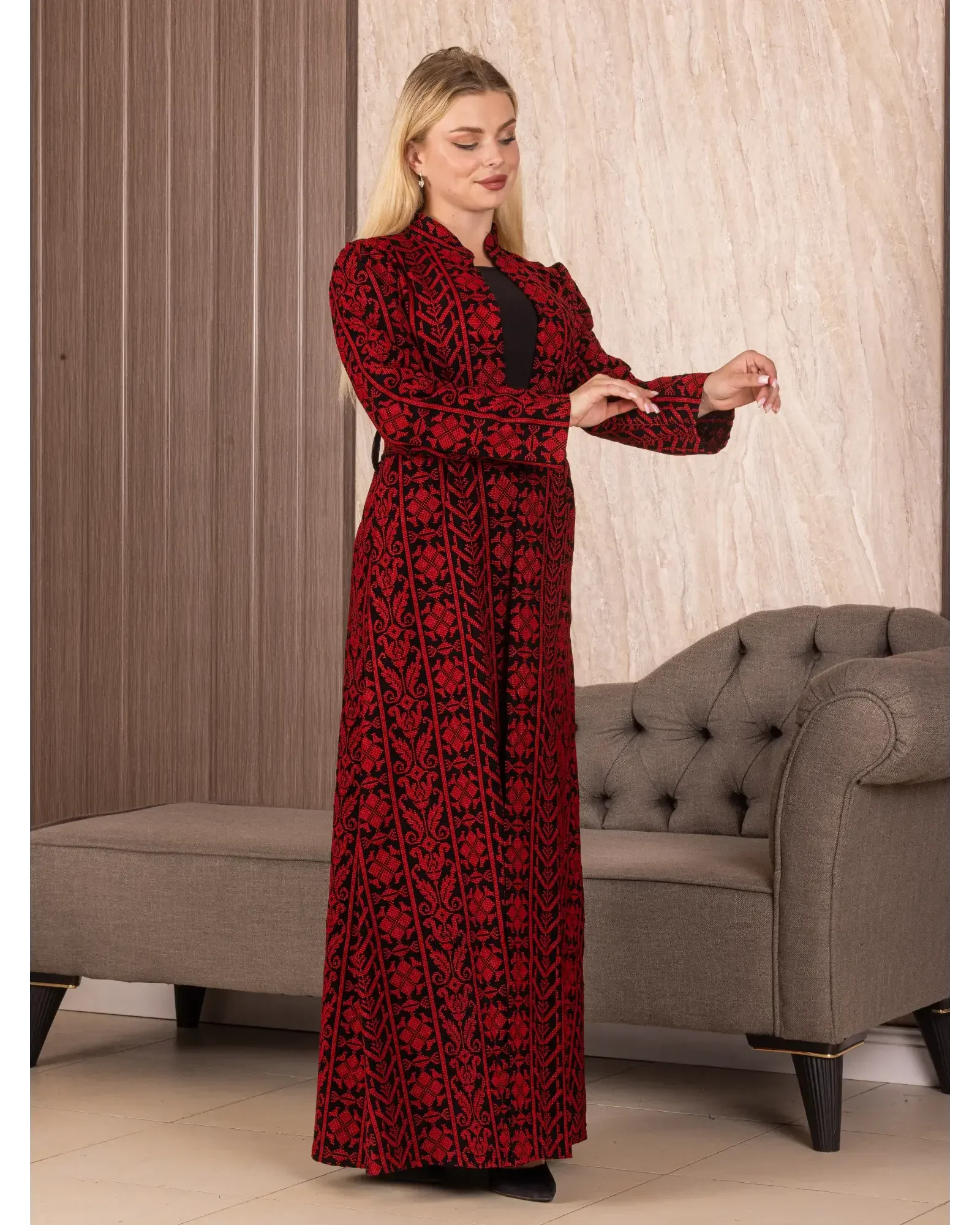 Palestinian Elegance embroidered long cardigan in red and black worn by a woman standing indoors
