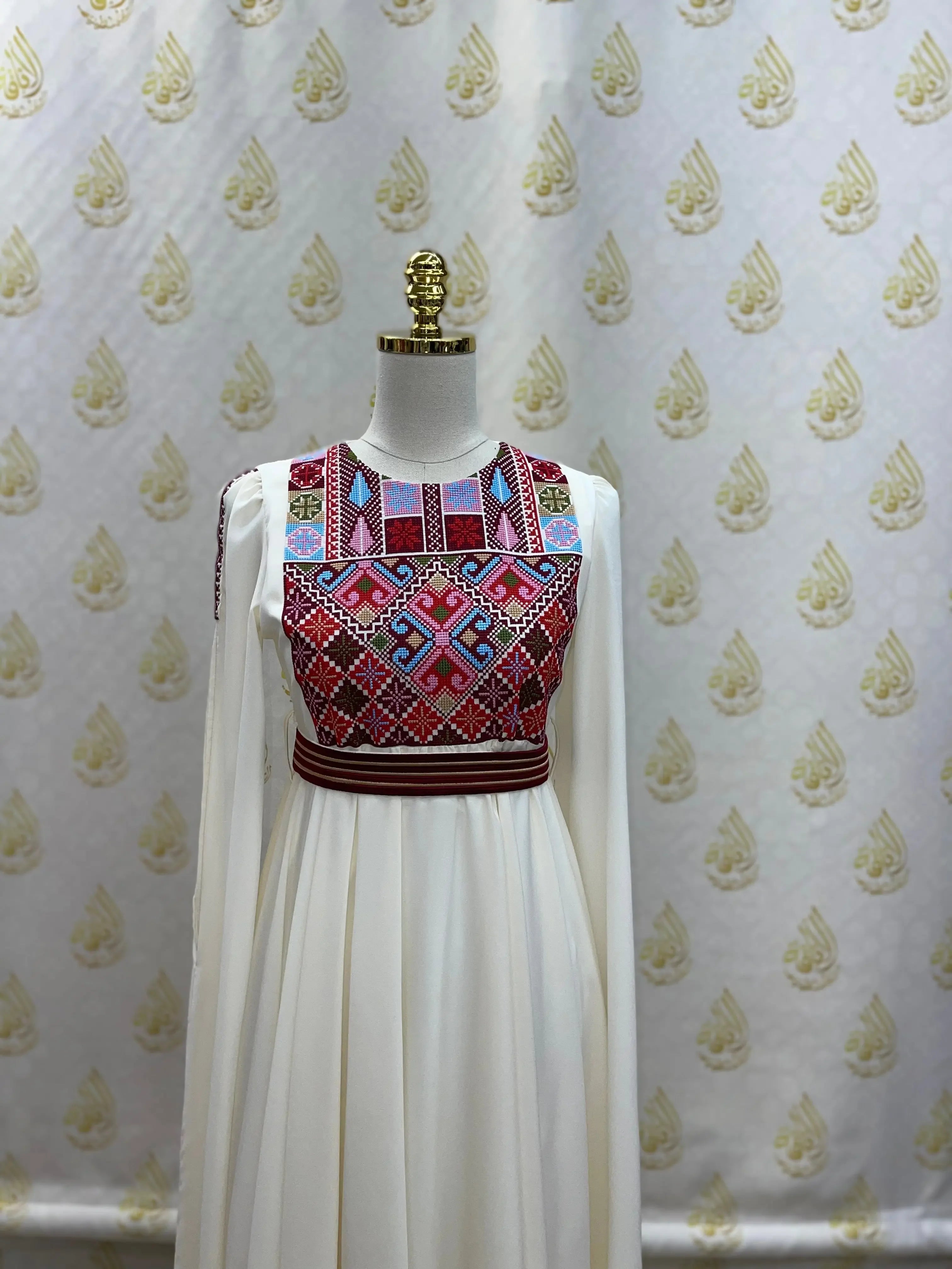 Palestinian girls embroidered dress with colorful geometric patterns on white fabric sleeveless top