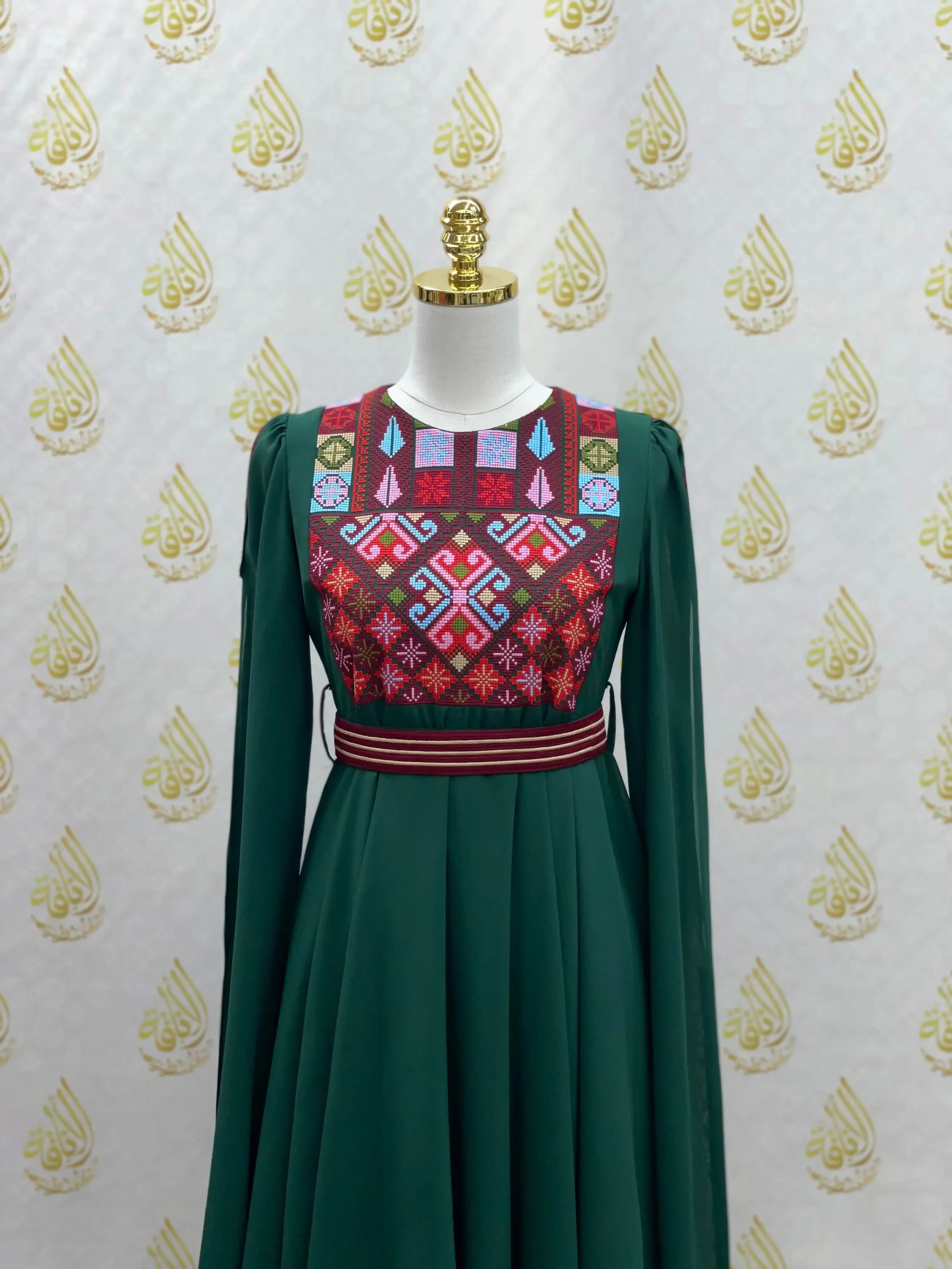 Palestinian girls embroidered dress with vibrant traditional patterns on a green long sleeve design