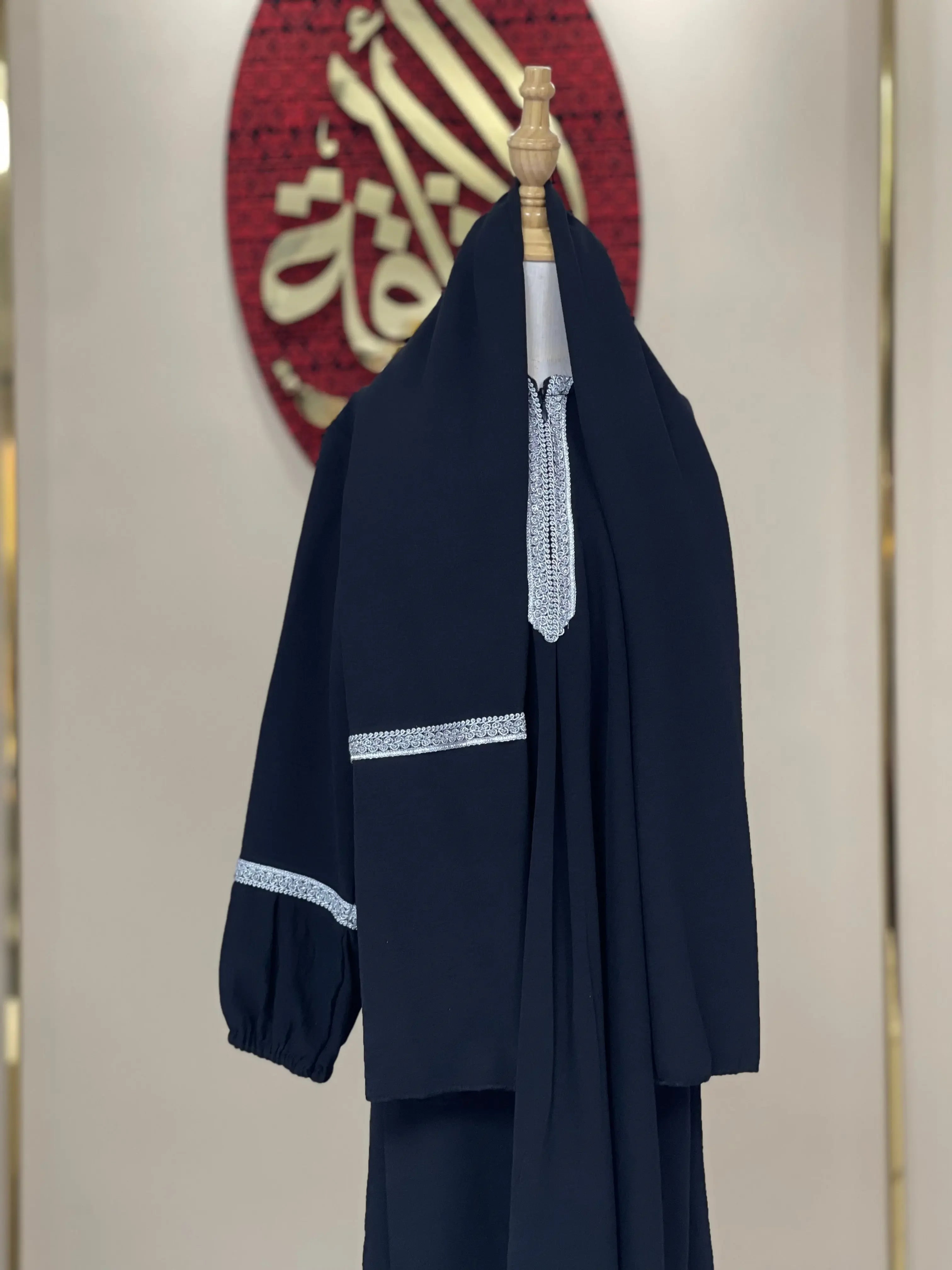 Girls embroidered abaya in black with white patterned embroidery on sleeves and neckline from Palestinian Elegance