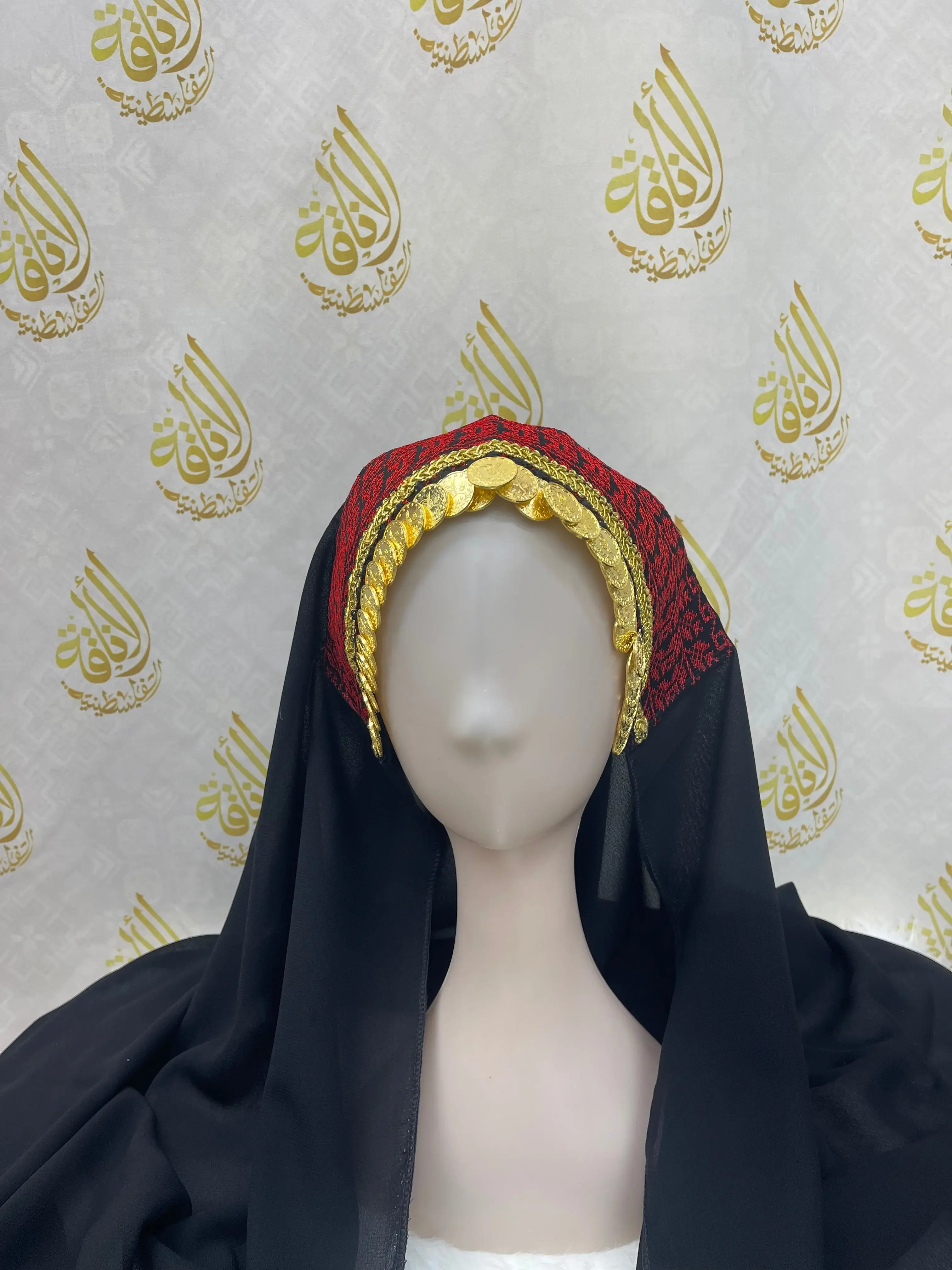 Palestinian embroidered khirka shawl in black and red draped on mannequin with gold detailing