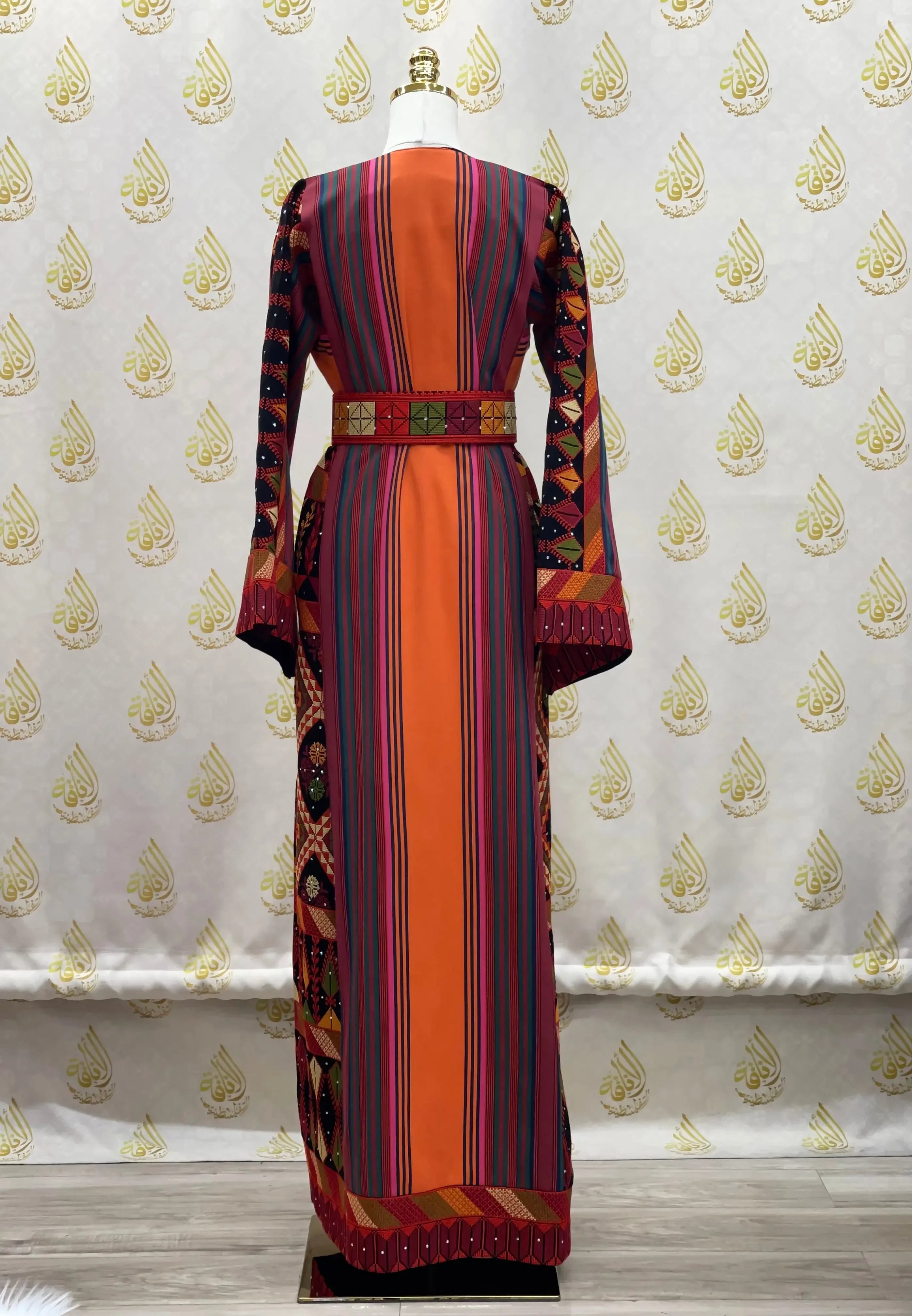 Back view of luxury Palestinian thoub dress with vibrant stripes and intricate embroidery by Palestinian Elegance