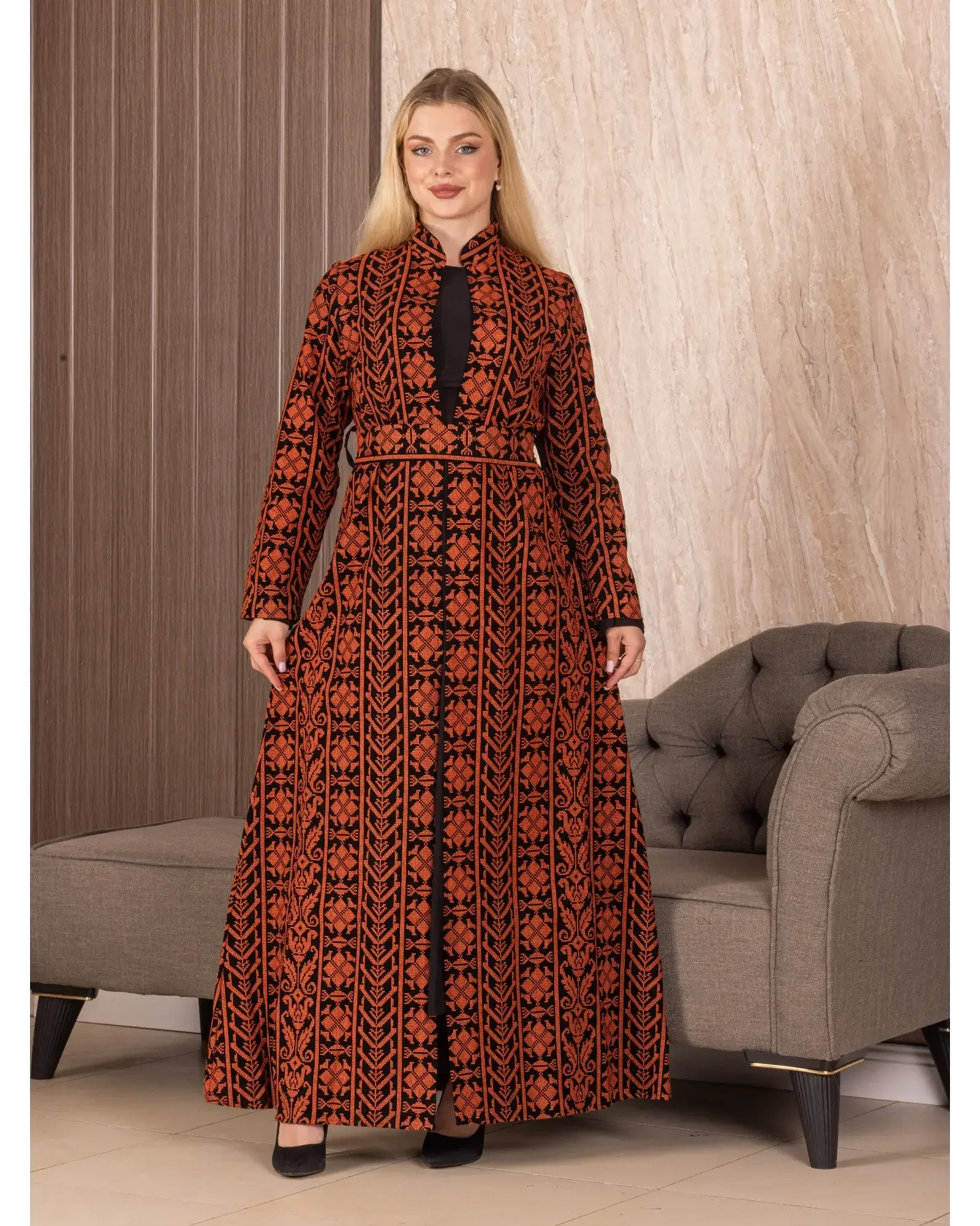 Palestinian Elegance embroidered long cardigan with intricate red and black designs worn by woman indoors