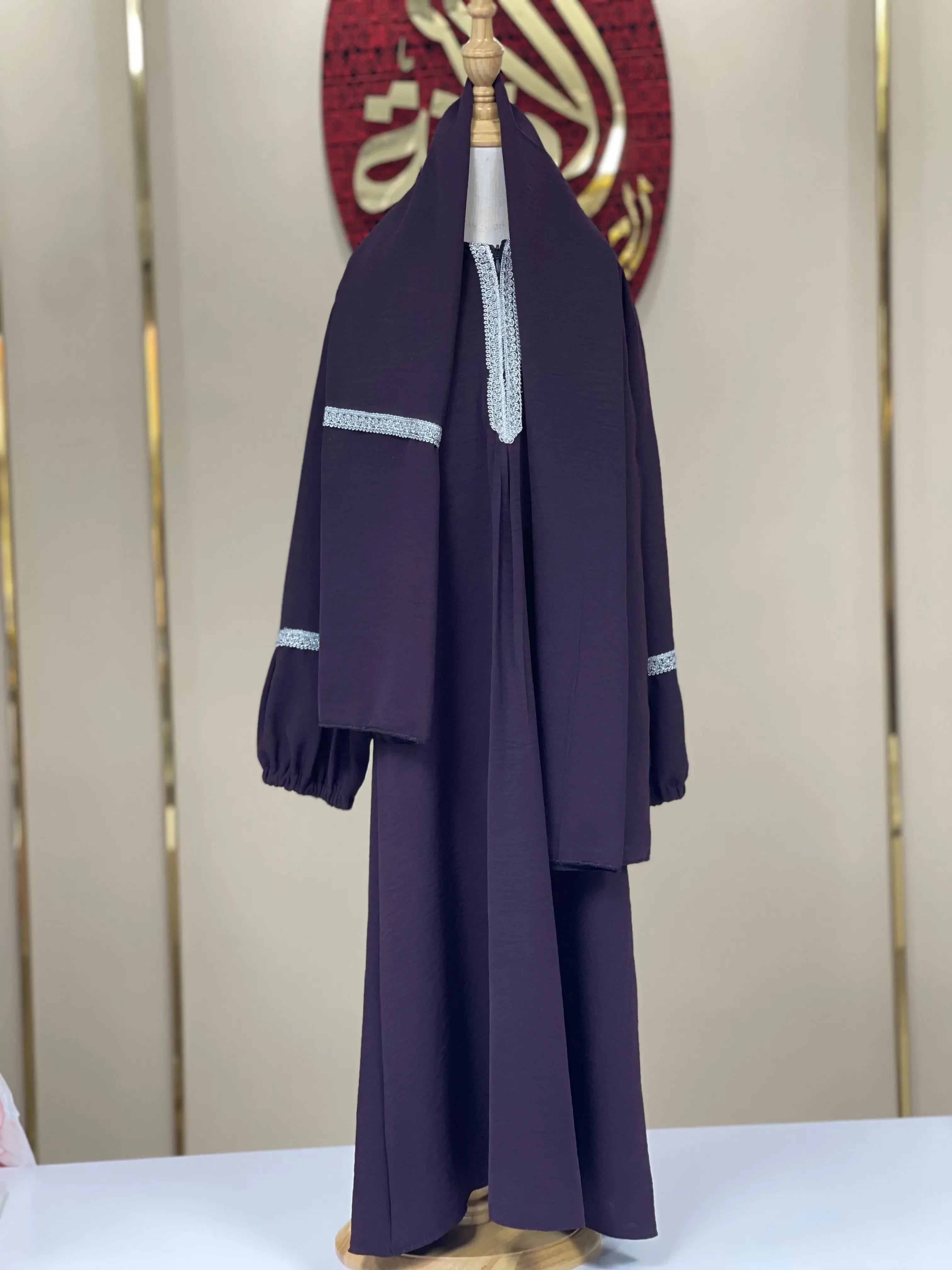 Girls embroidered abaya in dark fabric with light blue embroidered accents on sleeves and neckline