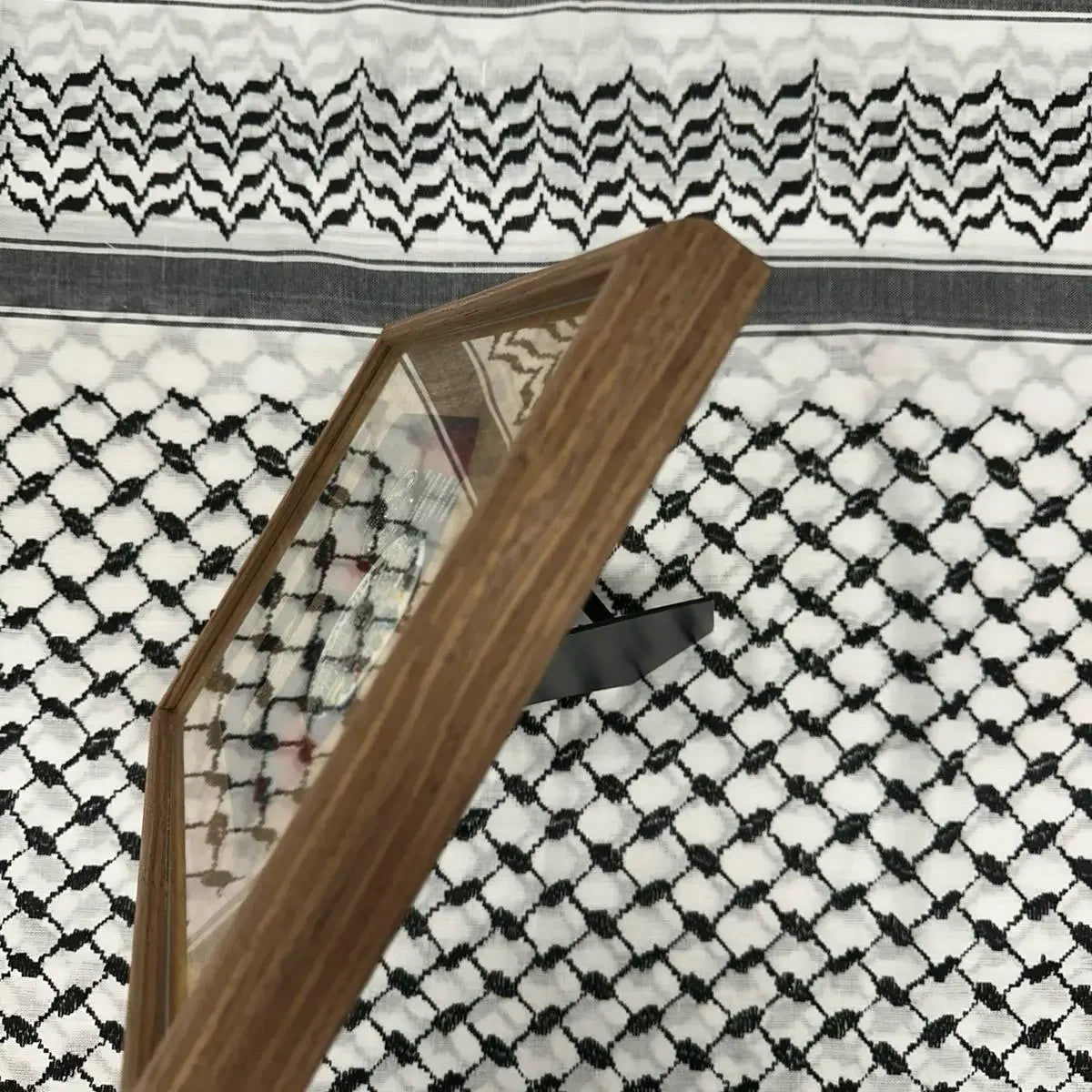 Palestinian embroidered wall art displayed in a wooden frame with traditional black and white embroidery background