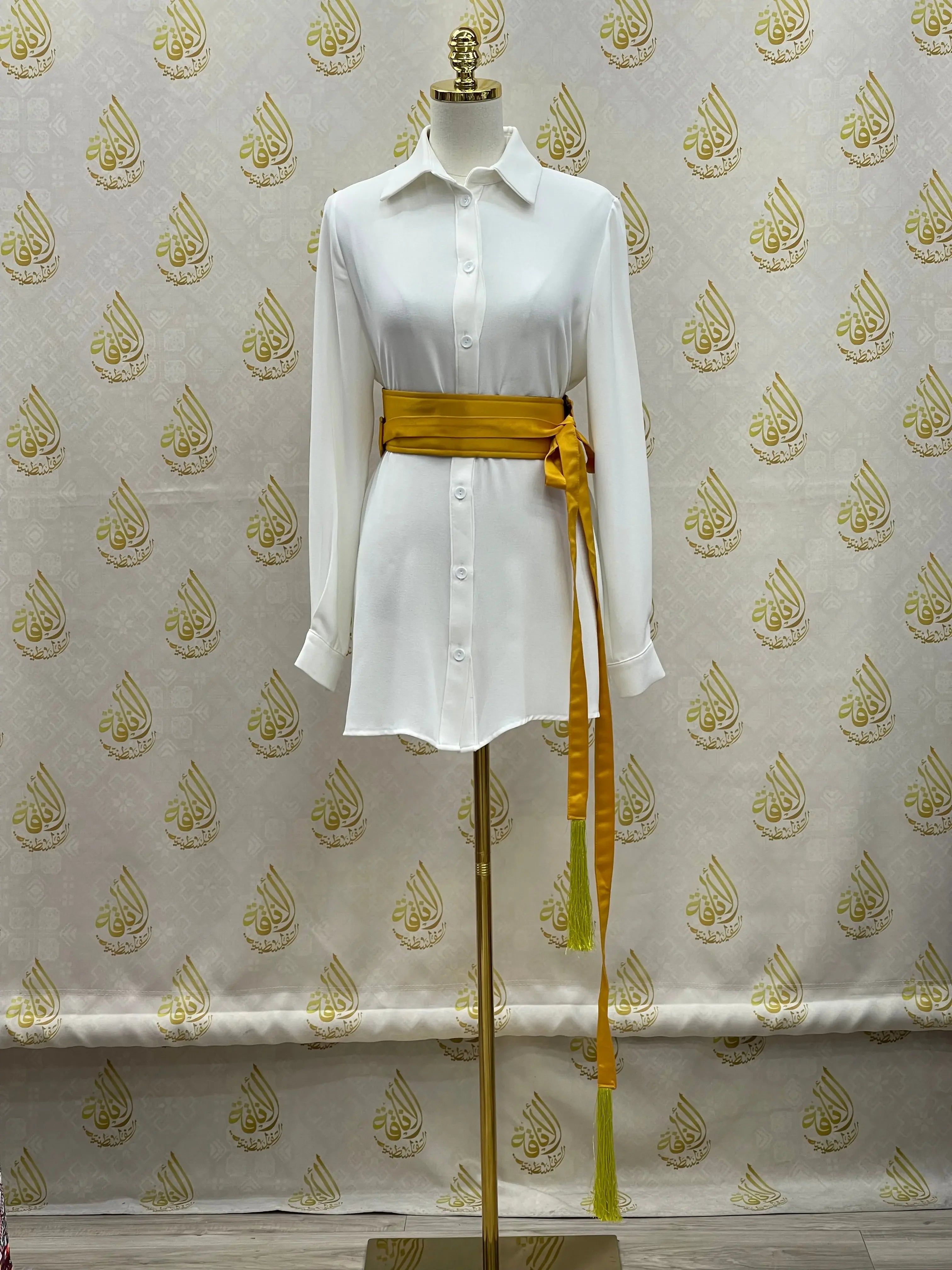Luxury satin belt for dresses in golden yellow paired with white button-up shirt dress on mannequin