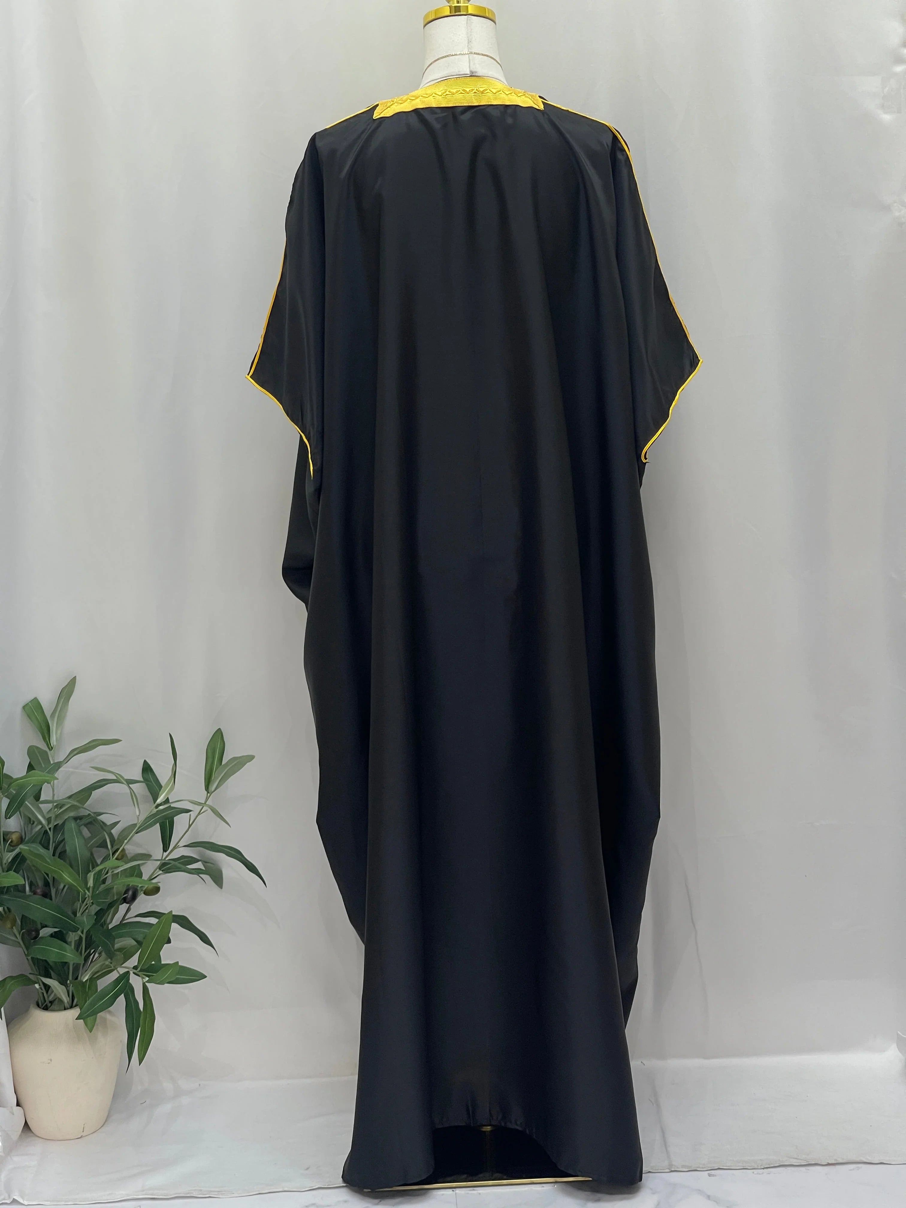 Mens Black Bisht with Golden Trim displayed from the back, featuring flowing fabric and elegant design