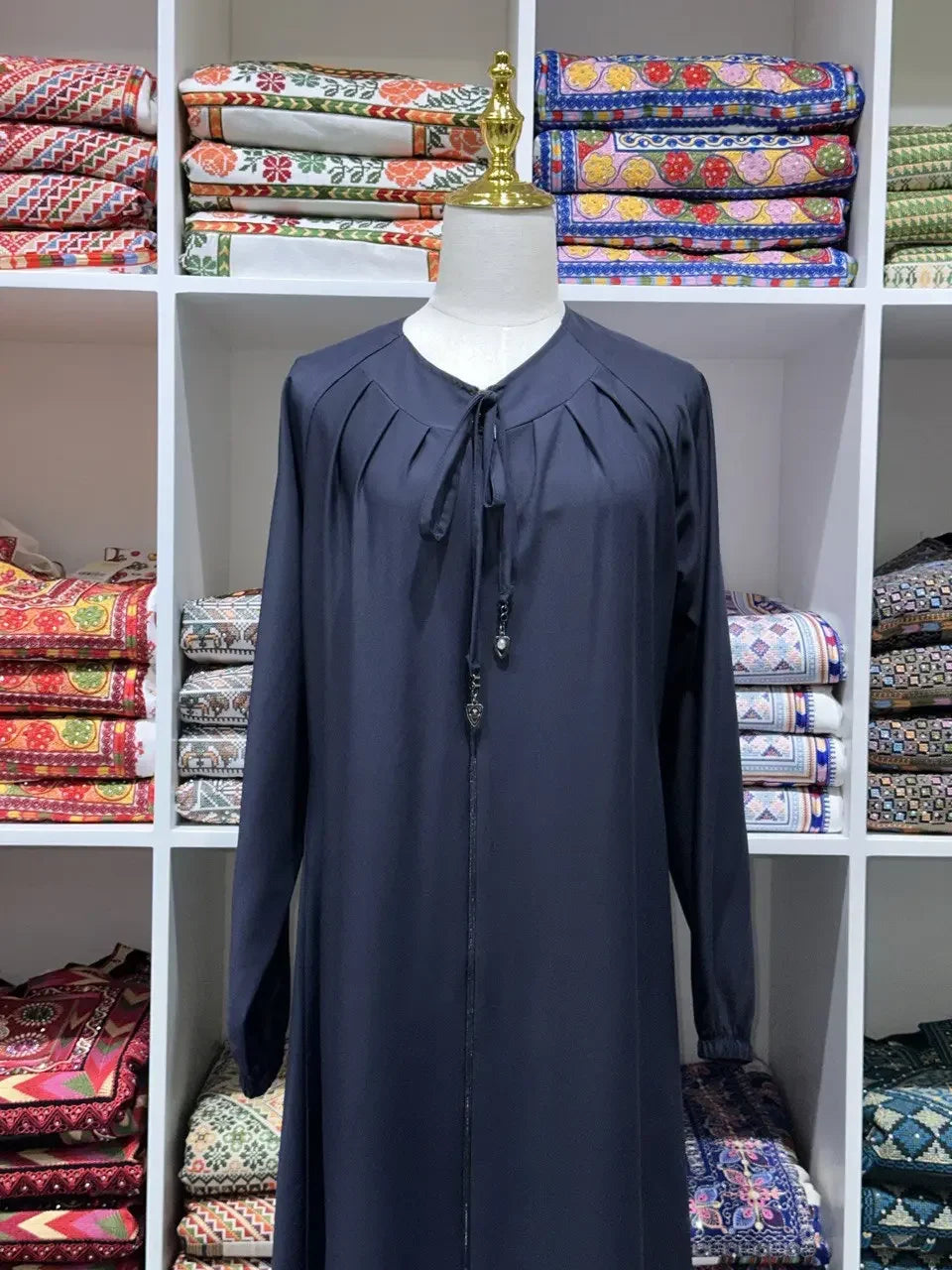 Palestinian Elegance umra abaya for women in black displayed on mannequin with long sleeves and tie neckline
