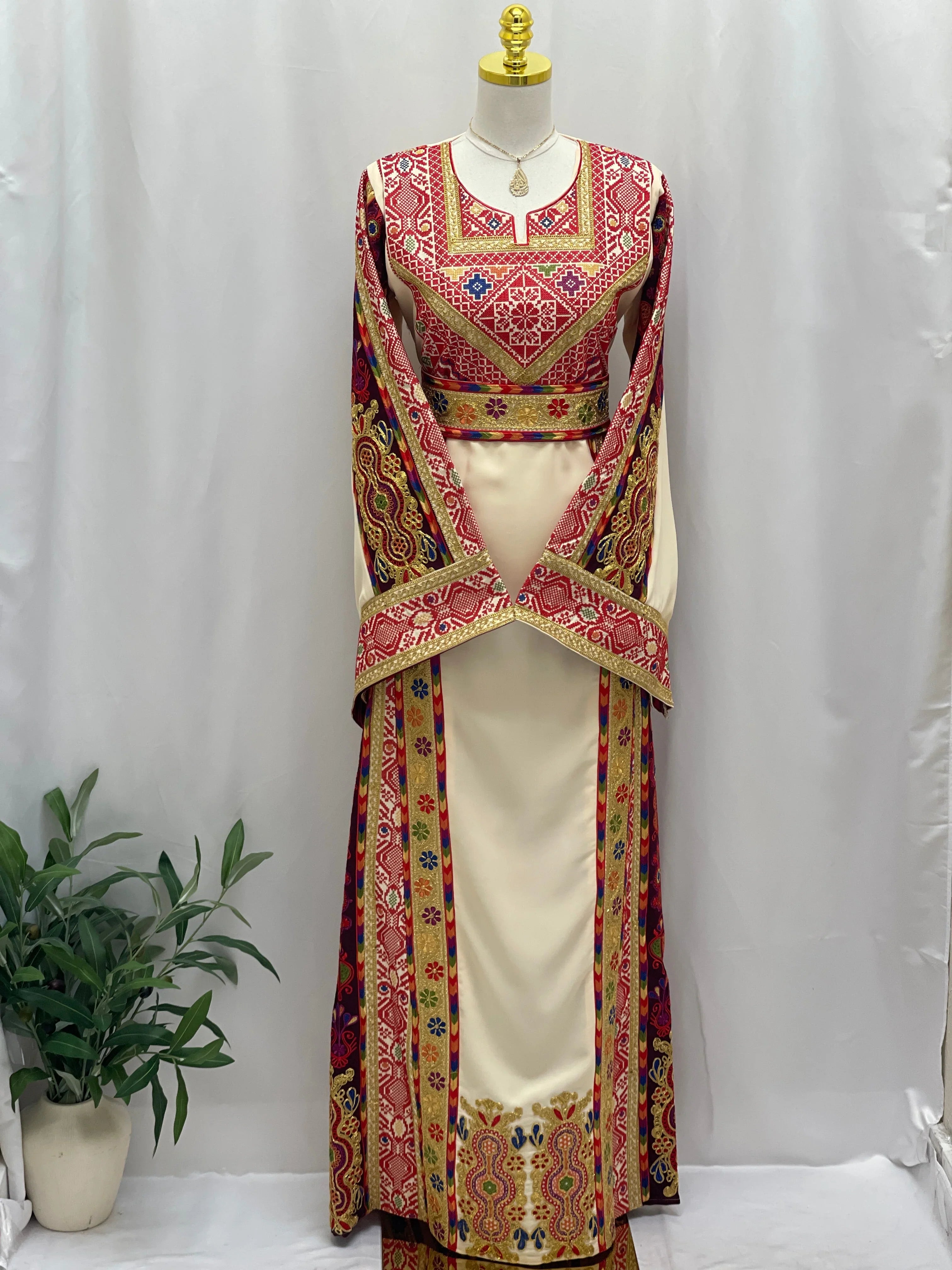 Al Kananiyyah Embroidered Thobe featuring intricate red and gold patterns with elegant long sleeves