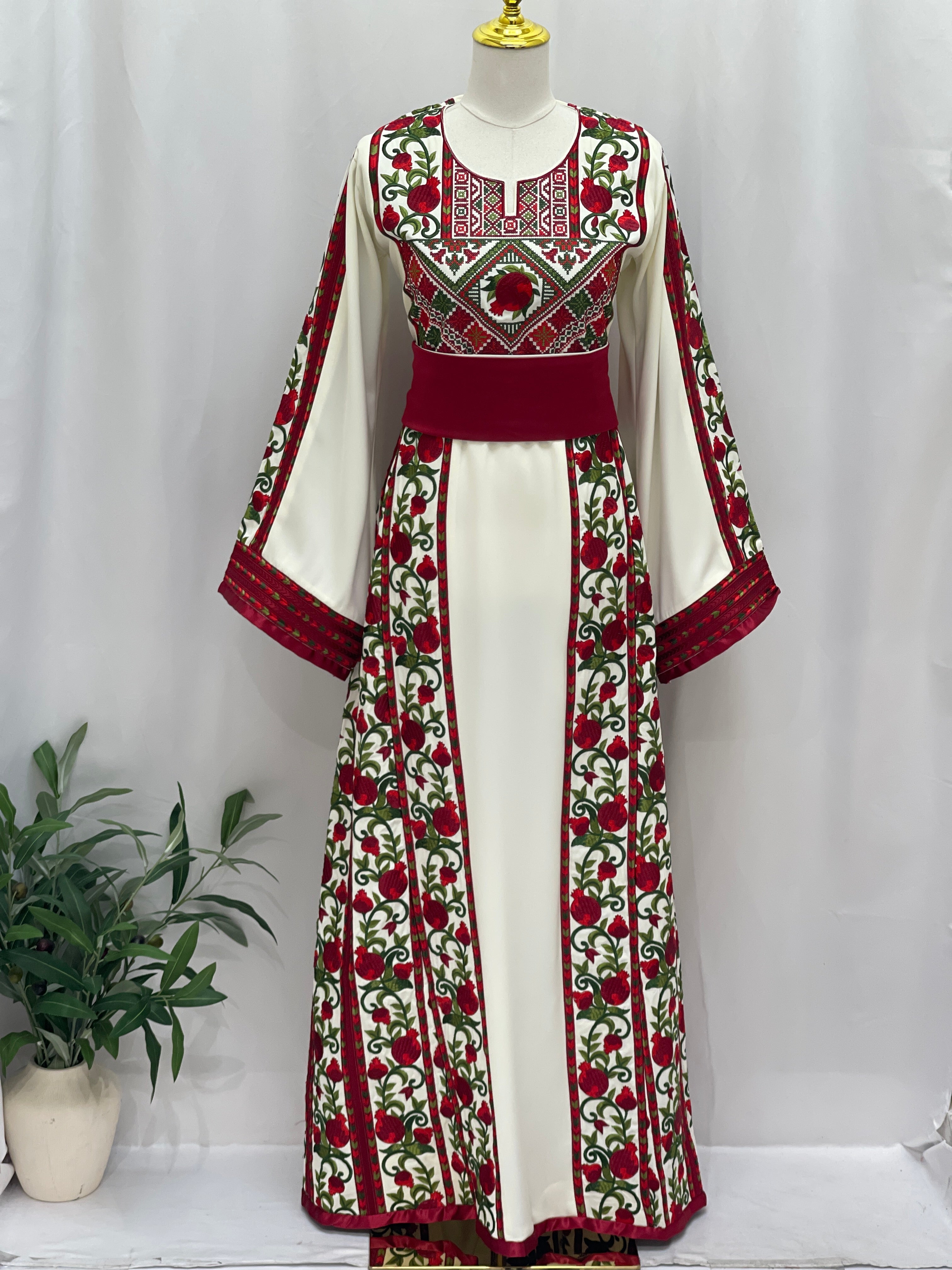 Al Romana Pomegranate Embroidered Thoub by Palestinian Elegance with intricate red and green floral embroidery on white fabric