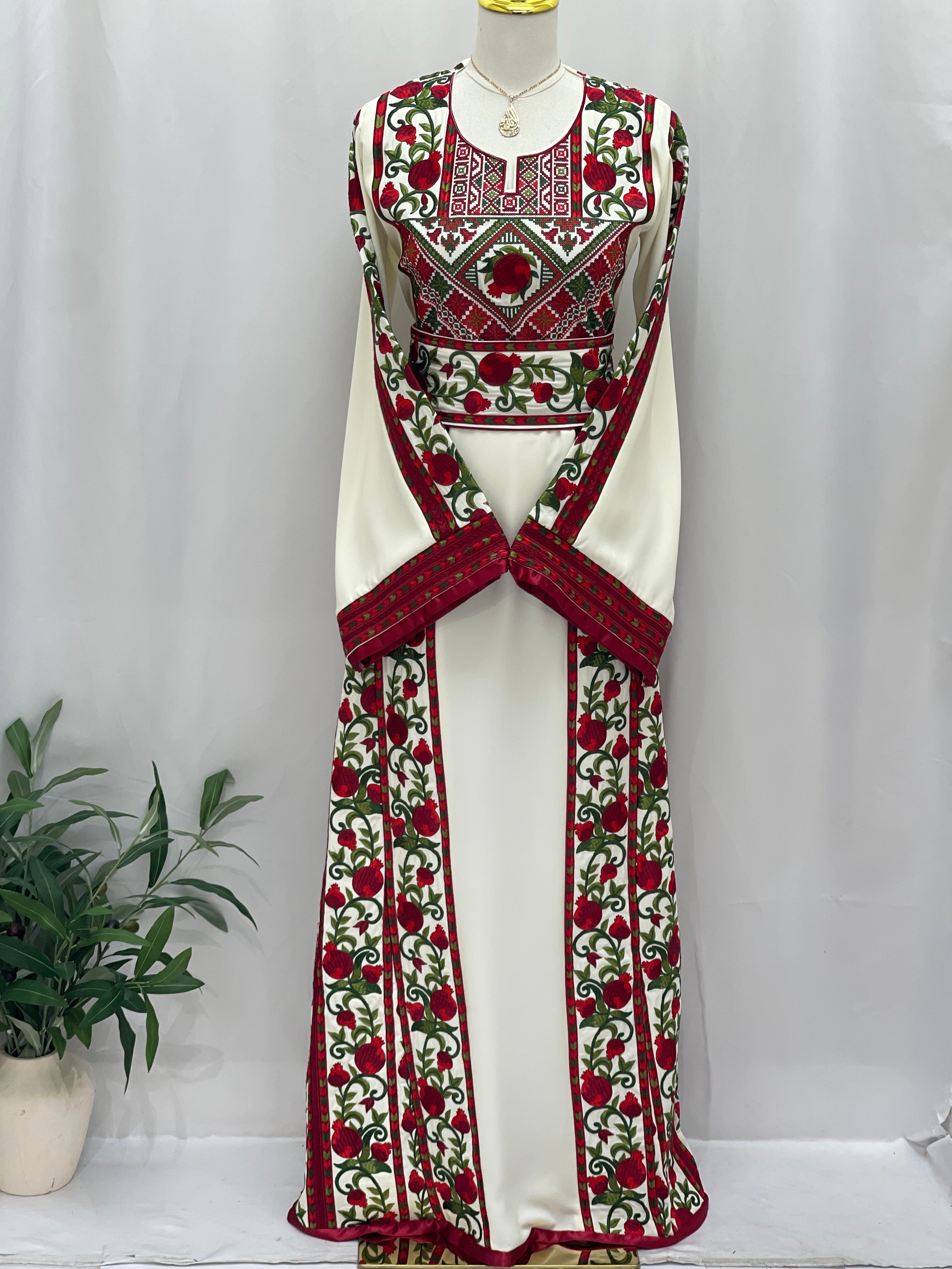 Palestinian Elegance Al Romana Pomegranate Embroidered Thoub with detailed red and green floral embroidery on white fabric