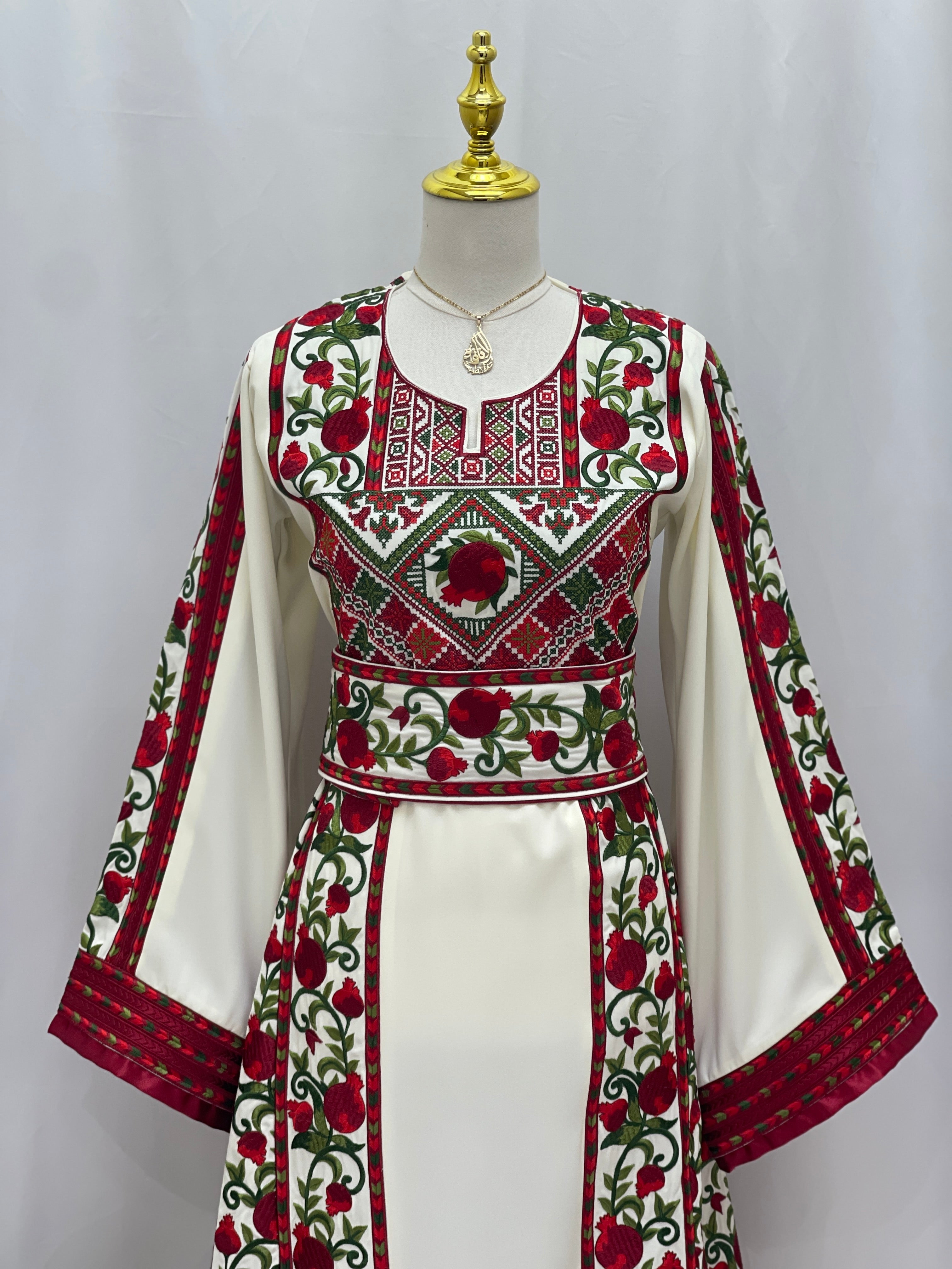 Al Romana Pomegranate Embroidered Thoub by Palestinian Elegance with embroidery on white fabric
