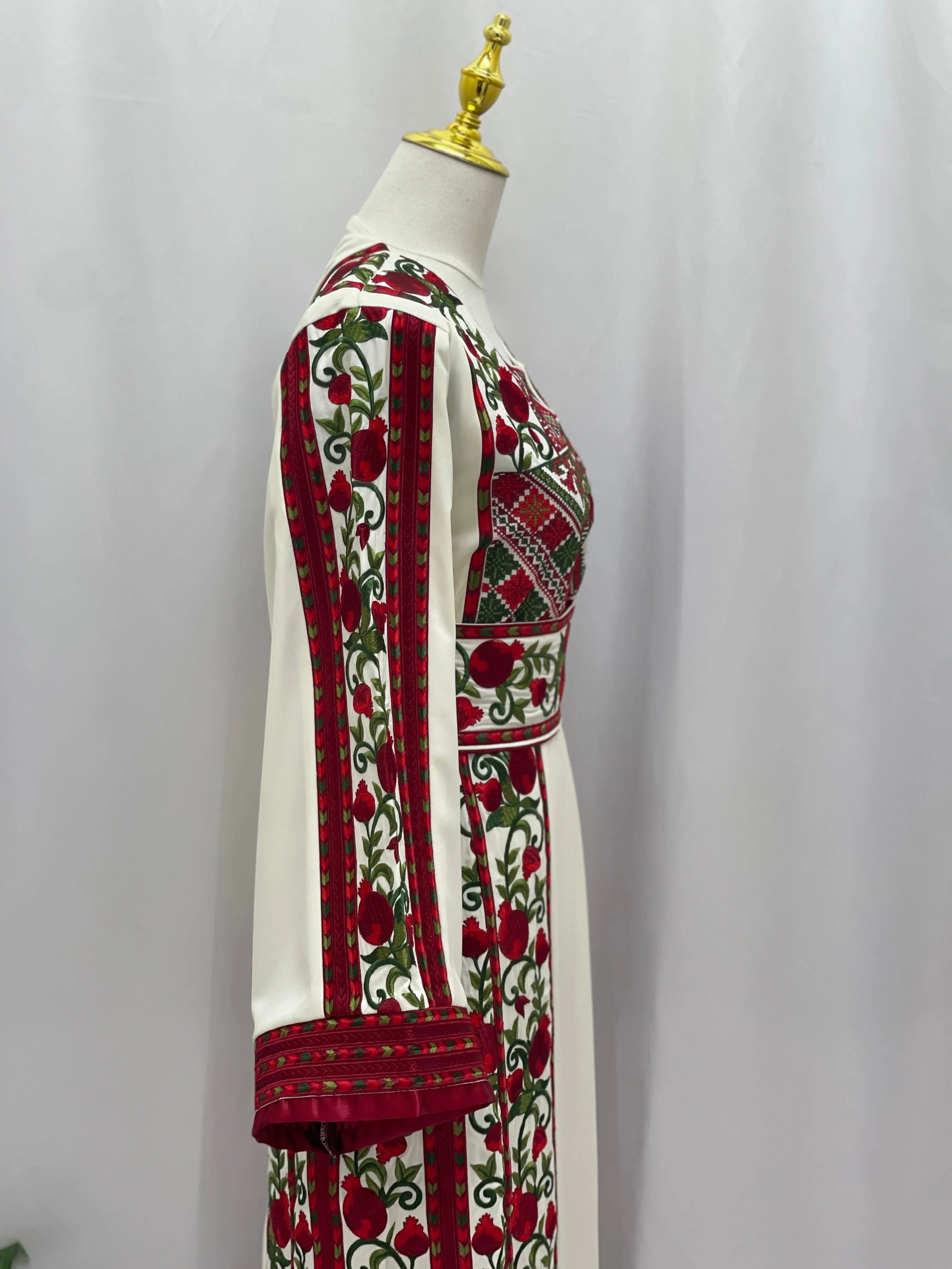 Al Romana Pomegranate Embroidered Thoub with red and green floral embroidery on white fabric by Palestinian Elegance