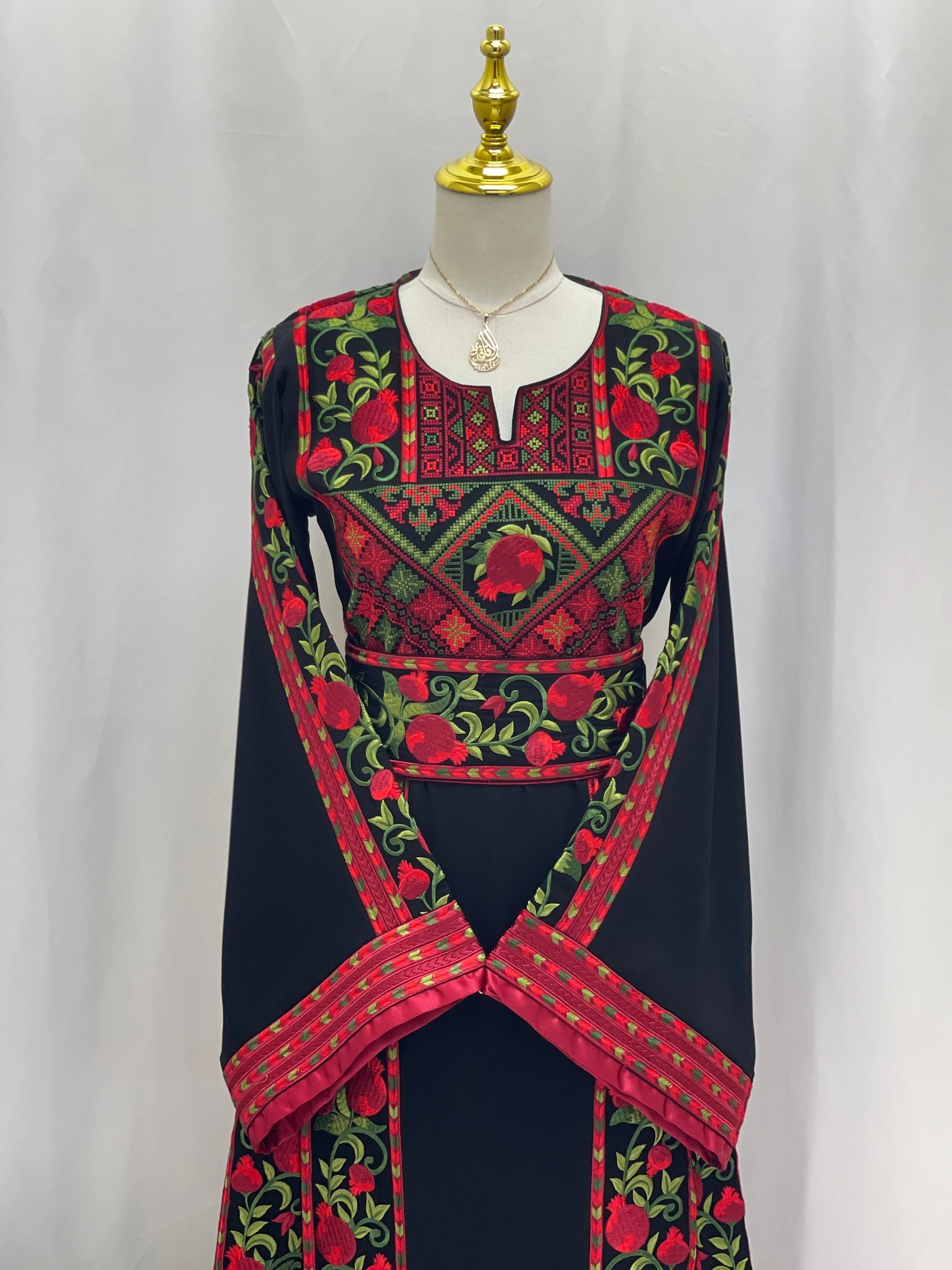 Palestinian Elegance Al Romana Pomegranate Embroidered Thoub with detailed red and green embroidery on black fabric