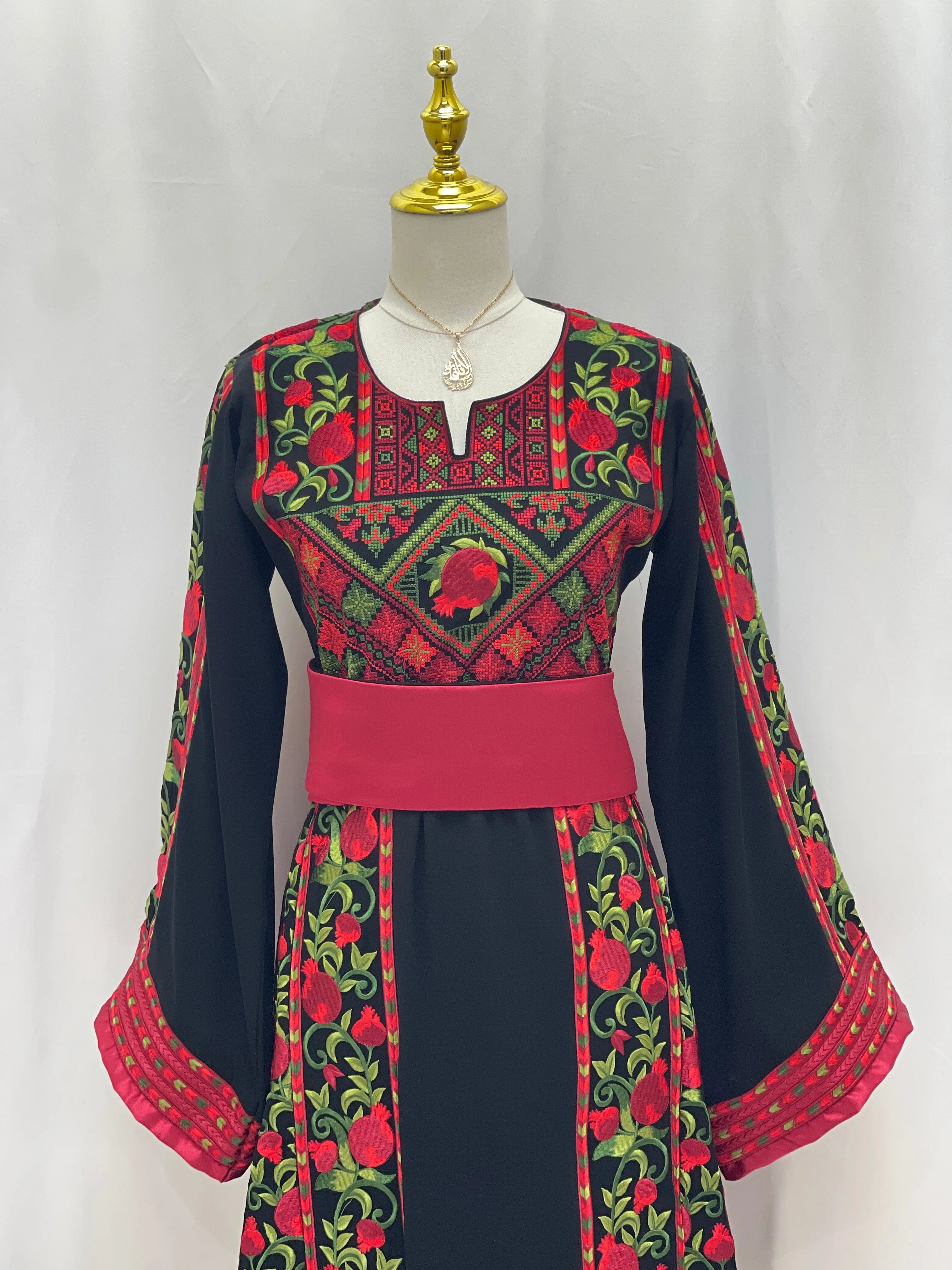 Al Romana Pomegranate Embroidered Thoub with vibrant red and green floral patterns on black fabric