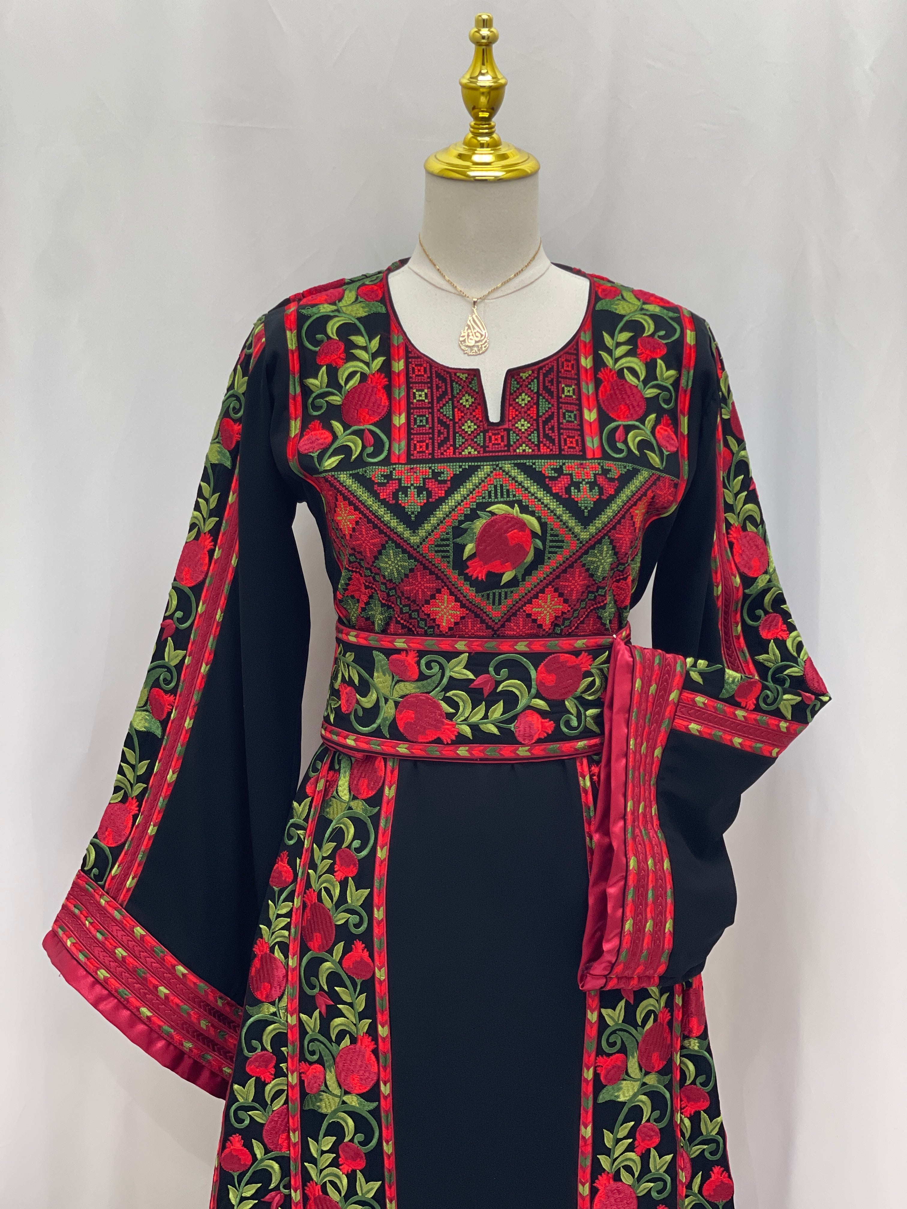 Al Romana Pomegranate Embroidered Thoub black fabric with red and green intricate embroidery by Palestinian Elegance