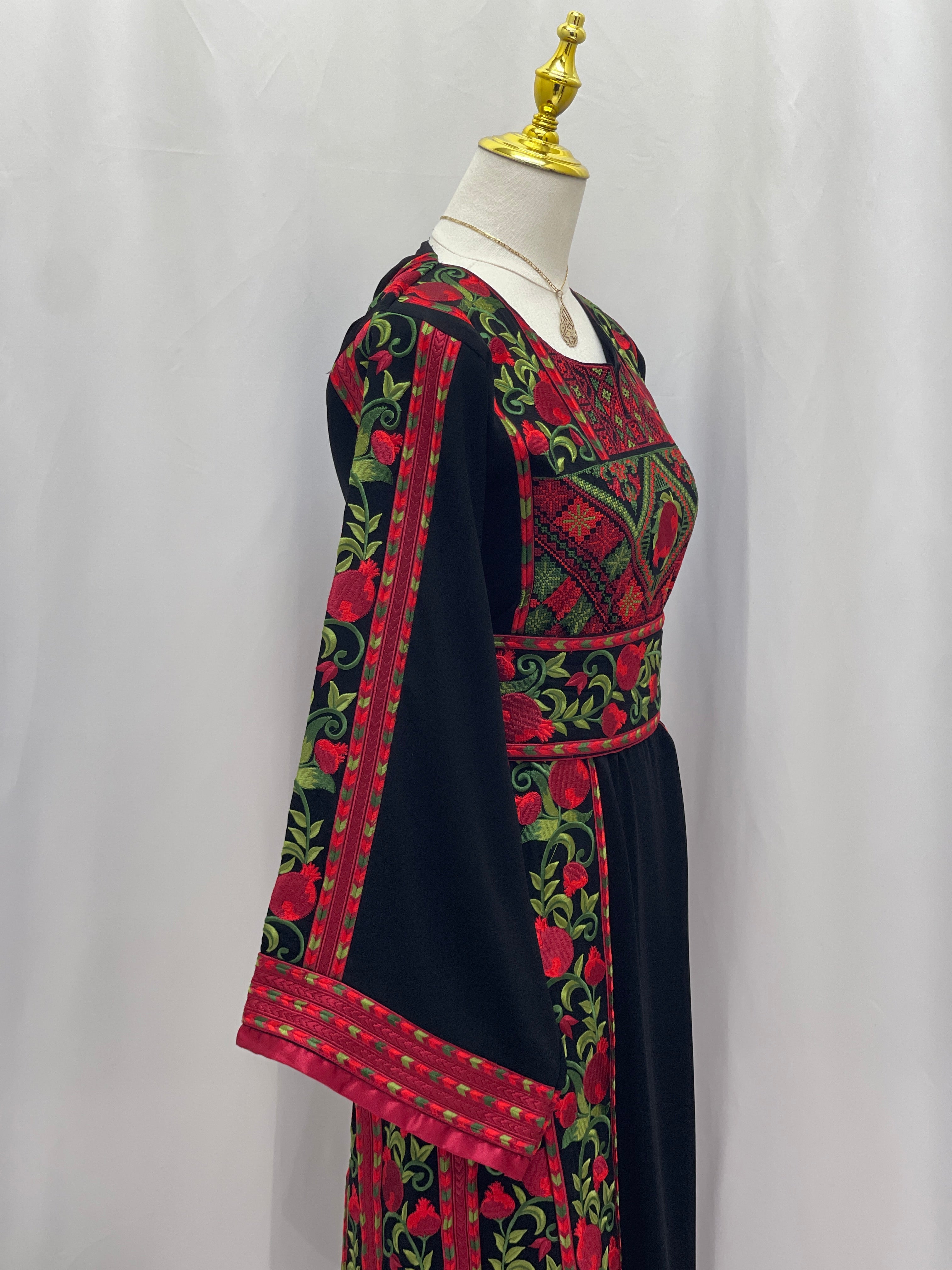 Palestinian Elegance Al Romana Pomegranate Embroidered Thoub with detailed red and green stitching on black fabric