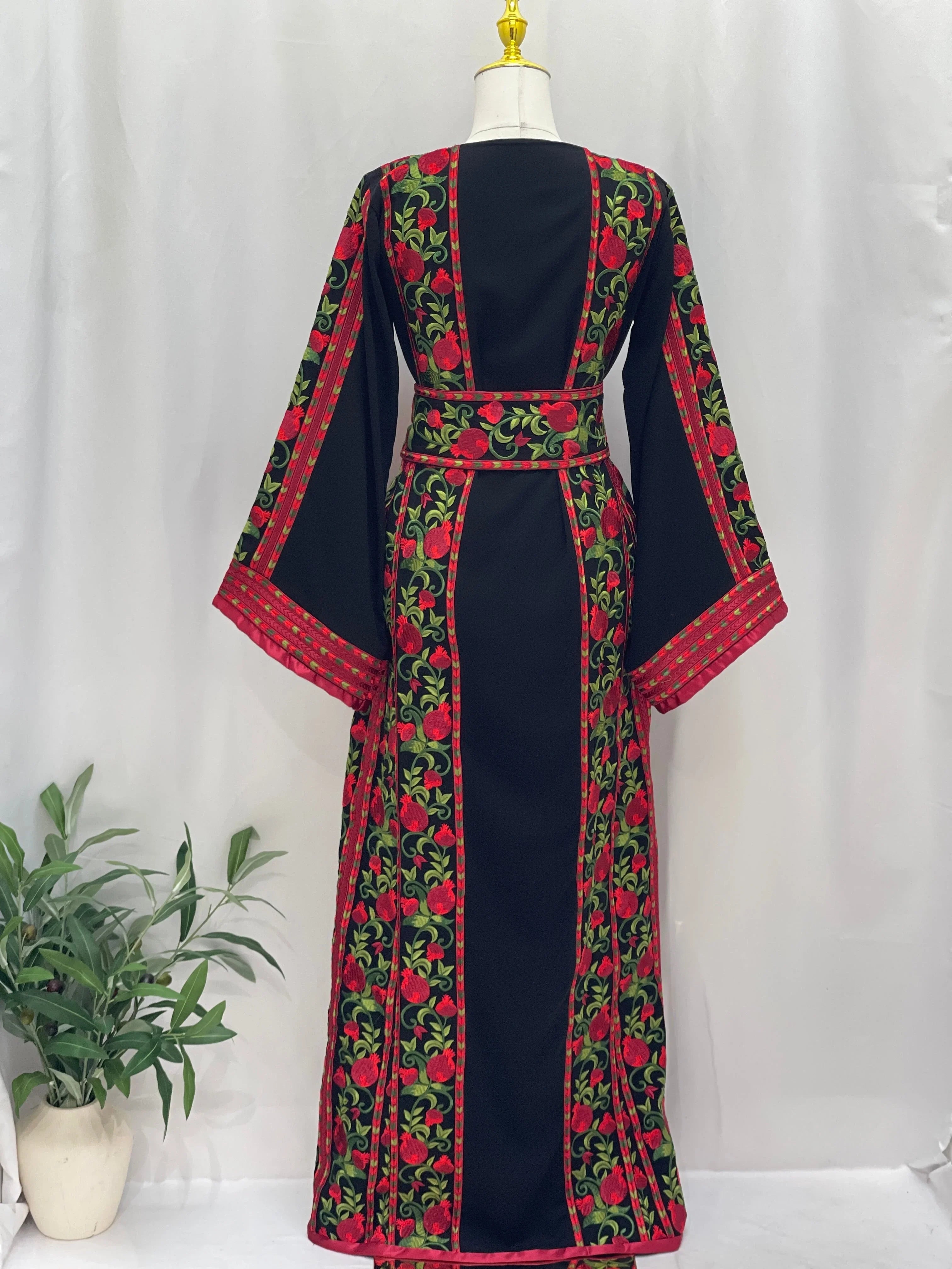 Palestinian Elegance Al Romana Pomegranate Embroidered Thoub with red and green floral on black fabric