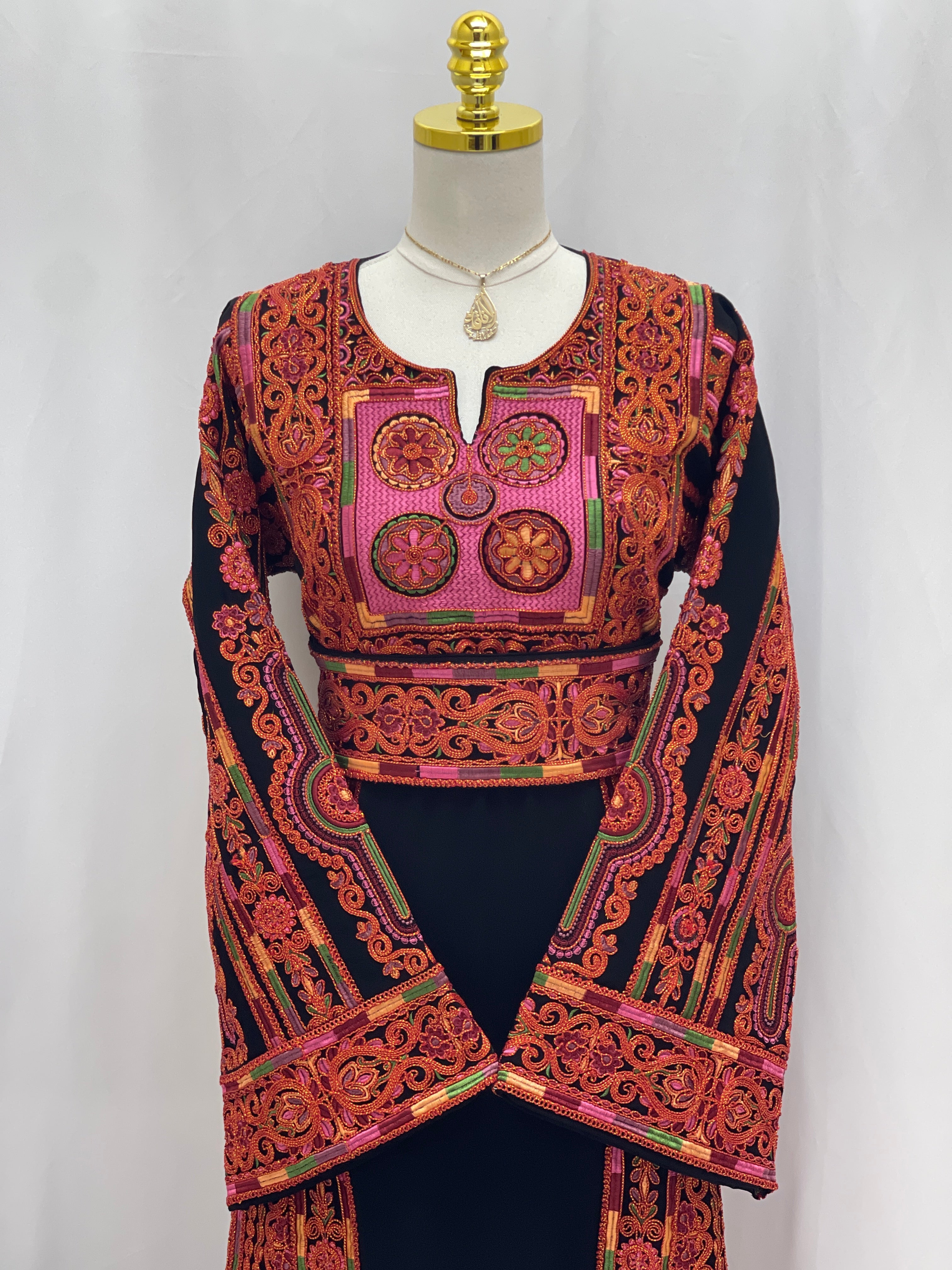 Al-Sundus Bream Embroidered Thobe black thobe with vibrant red orange chest panel and long embroidered sleeves