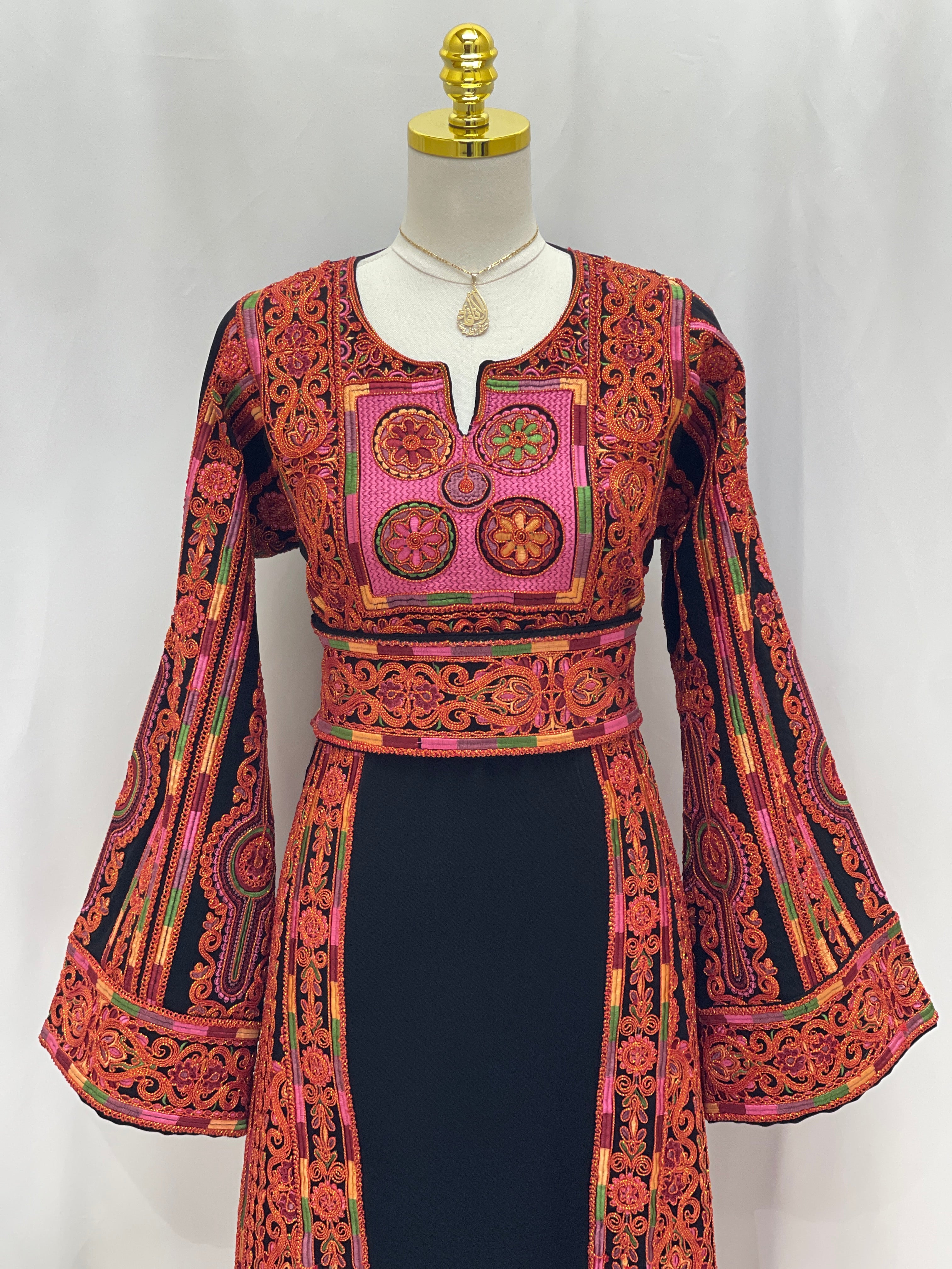Palestinian Elegance Al-Sundus Bream Embroidered Thobe black dress with red orange cross stitched embroidery and bell sleeves
