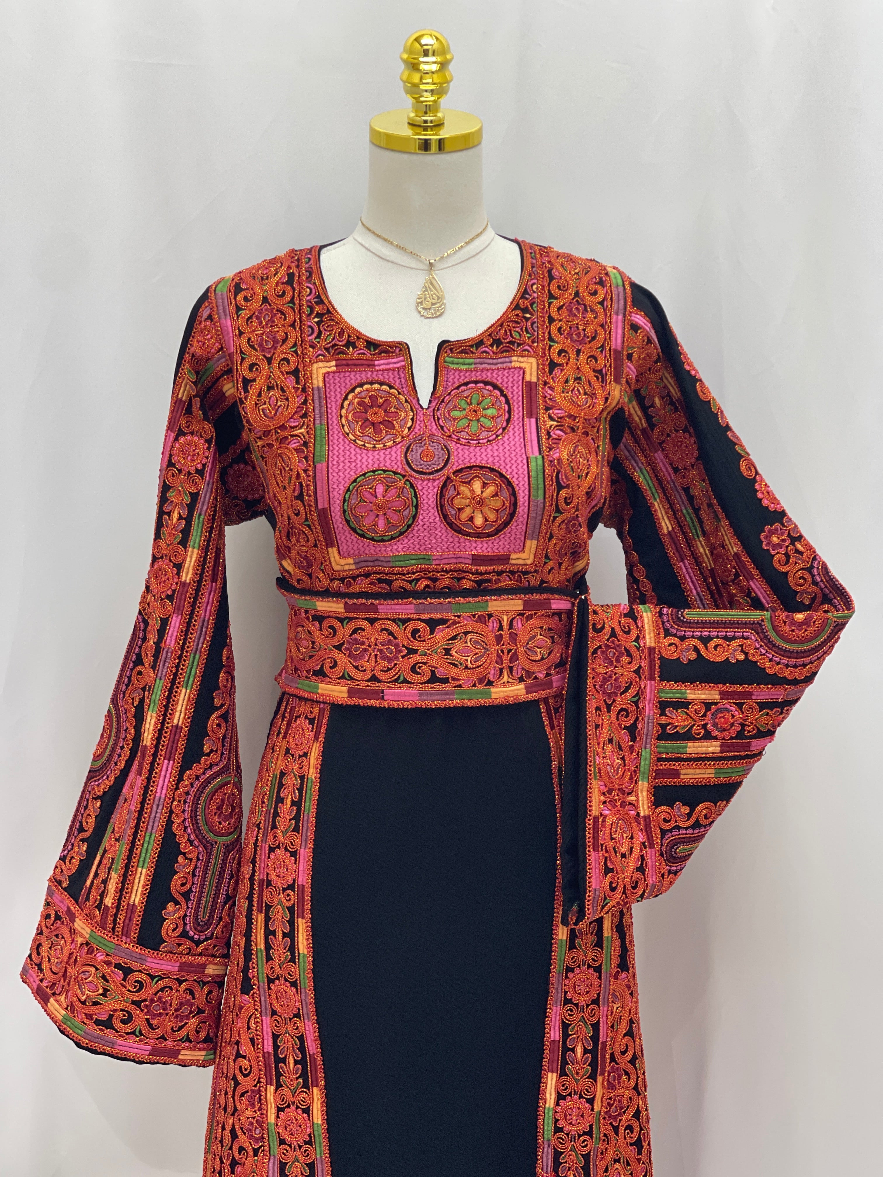 Palestinian Elegance Al-Sundus Bream Embroidered Thobe . Black thobe with red and orange hand embroidery on chest sleeves and belt