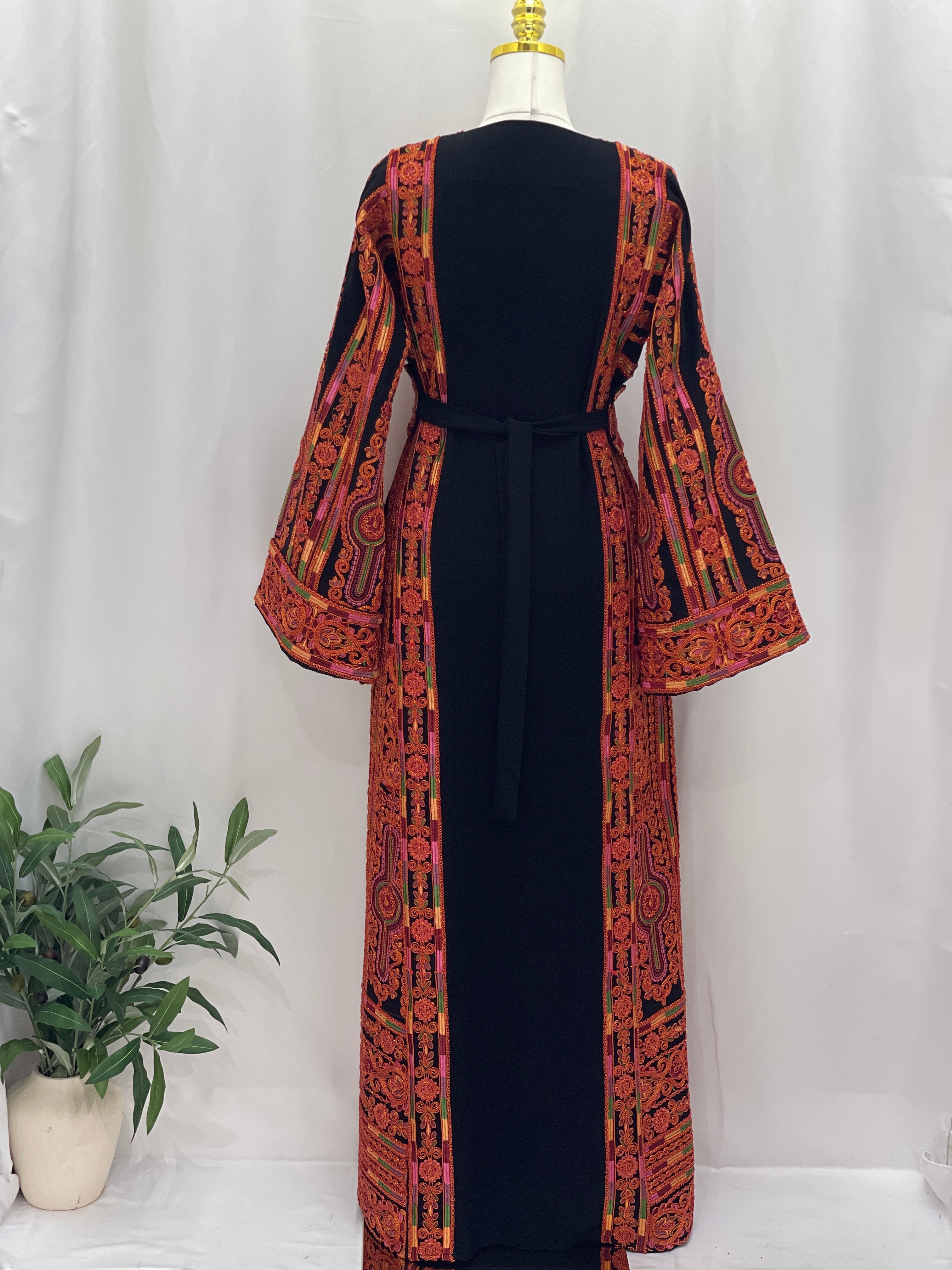 Palestinian Elegance Al-Sundus Bream Embroidered Thobe . Black thobe with orange embroidered panels bell sleeves and waist tie
