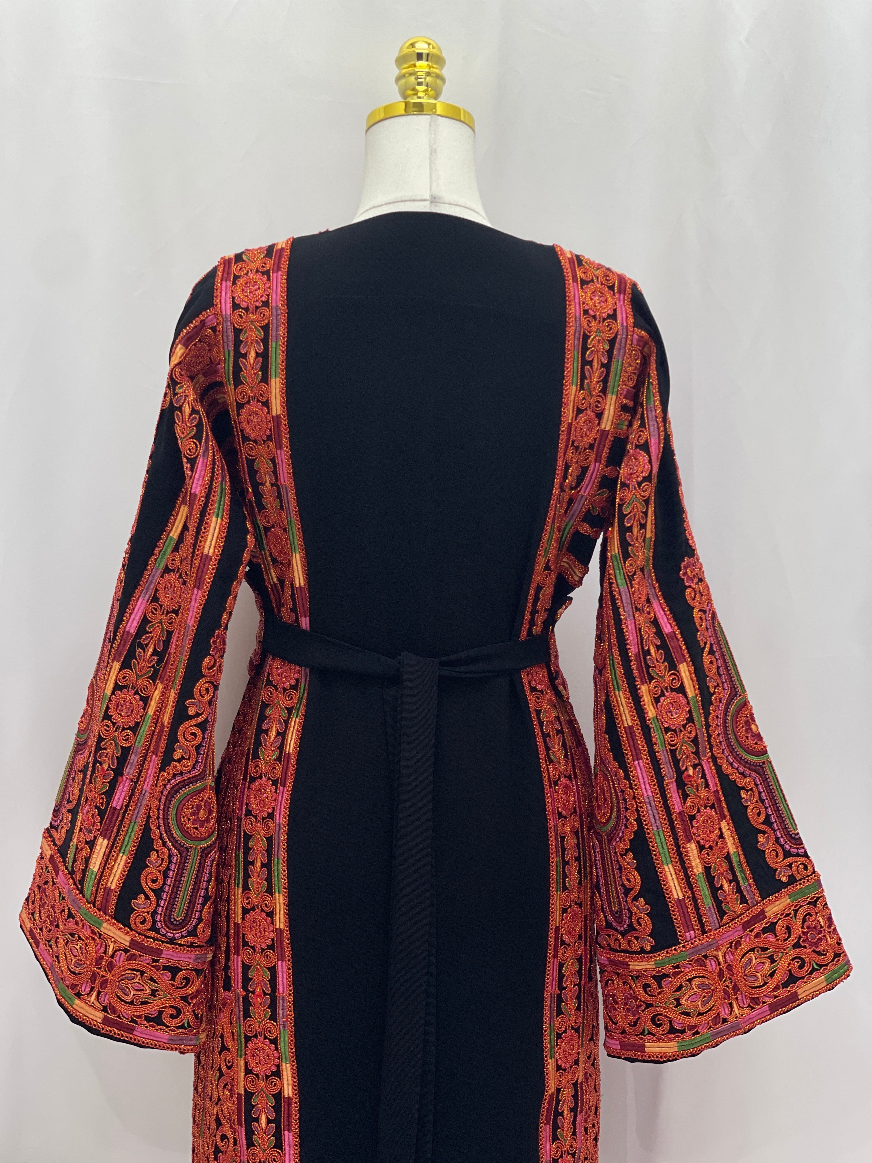 Al-Sundus Bream Embroidered Thobe back view black thobe with bold red orange Palestinian embroidery and bell sleeves