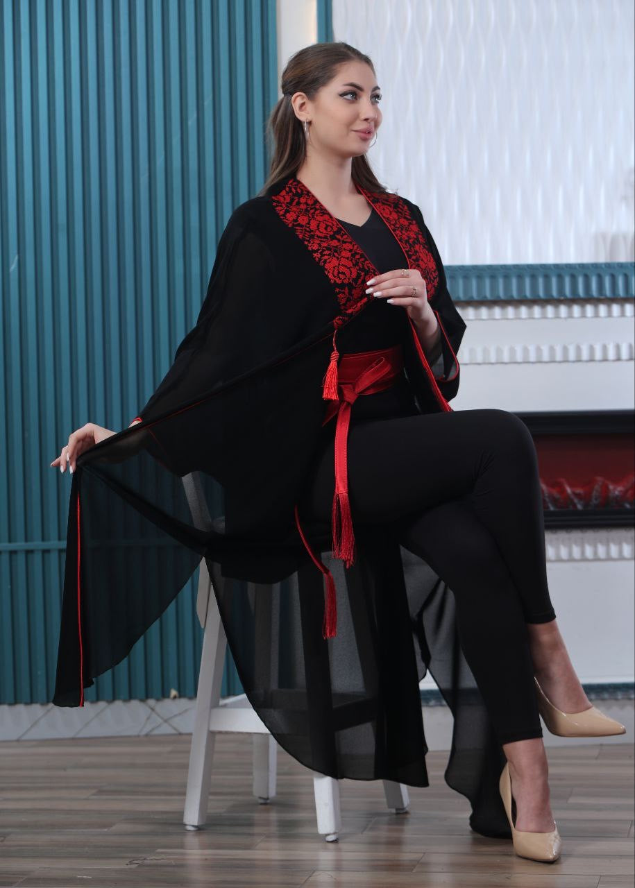 Palestinian Elegance luxury embroidered bisht in black with red embroidery worn by seated woman