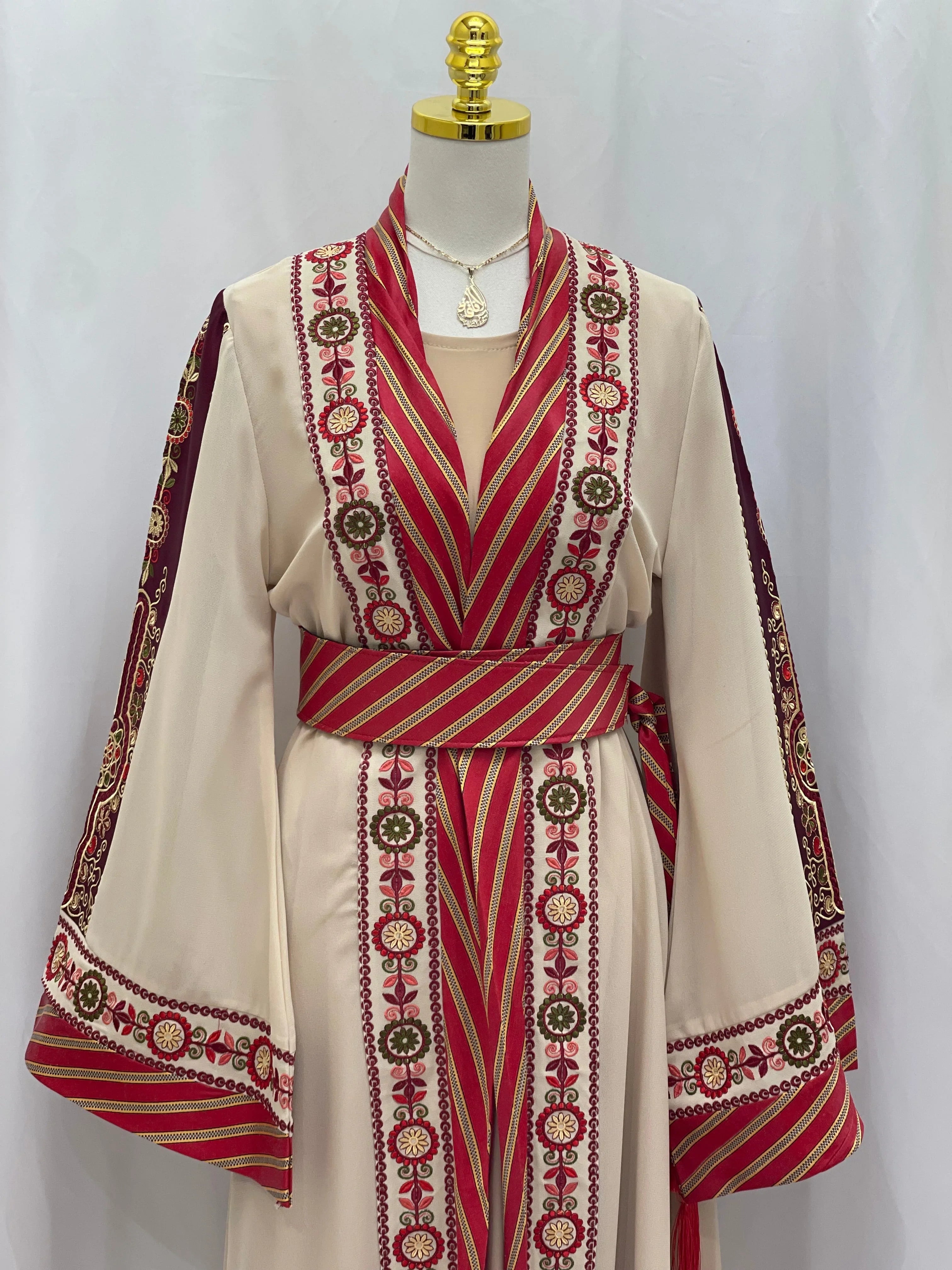 Palestinian Elegance embroidered Kashmir abaya with intricate red and gold embroidery and matching belt on mannequin