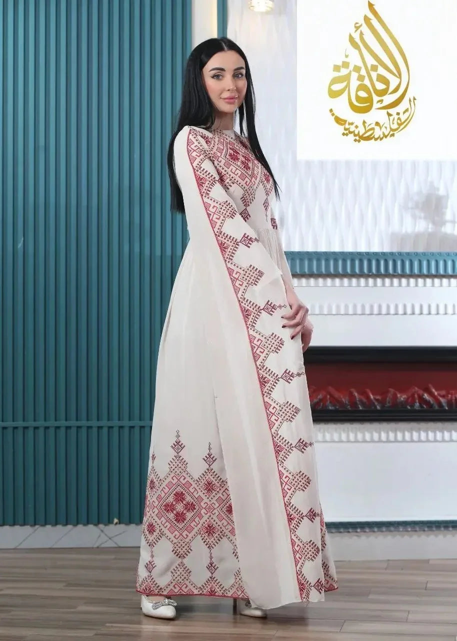 Woman wearing a modern embroidered Palestinian dress with red geometric designs by Palestinian Elegance