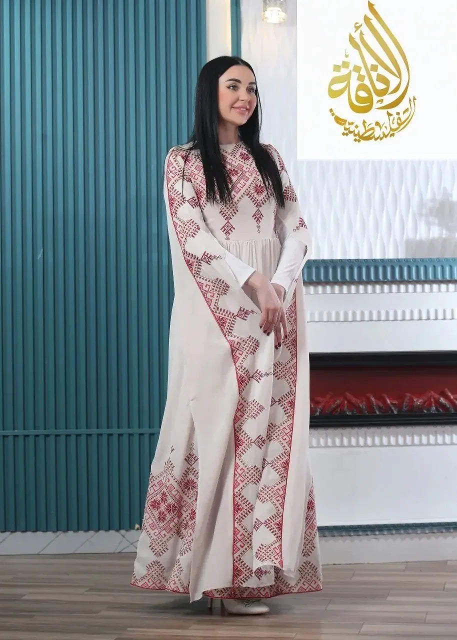 Woman wearing a modern embroidered Palestinian dress by Palestinian Elegance with intricate red patterns