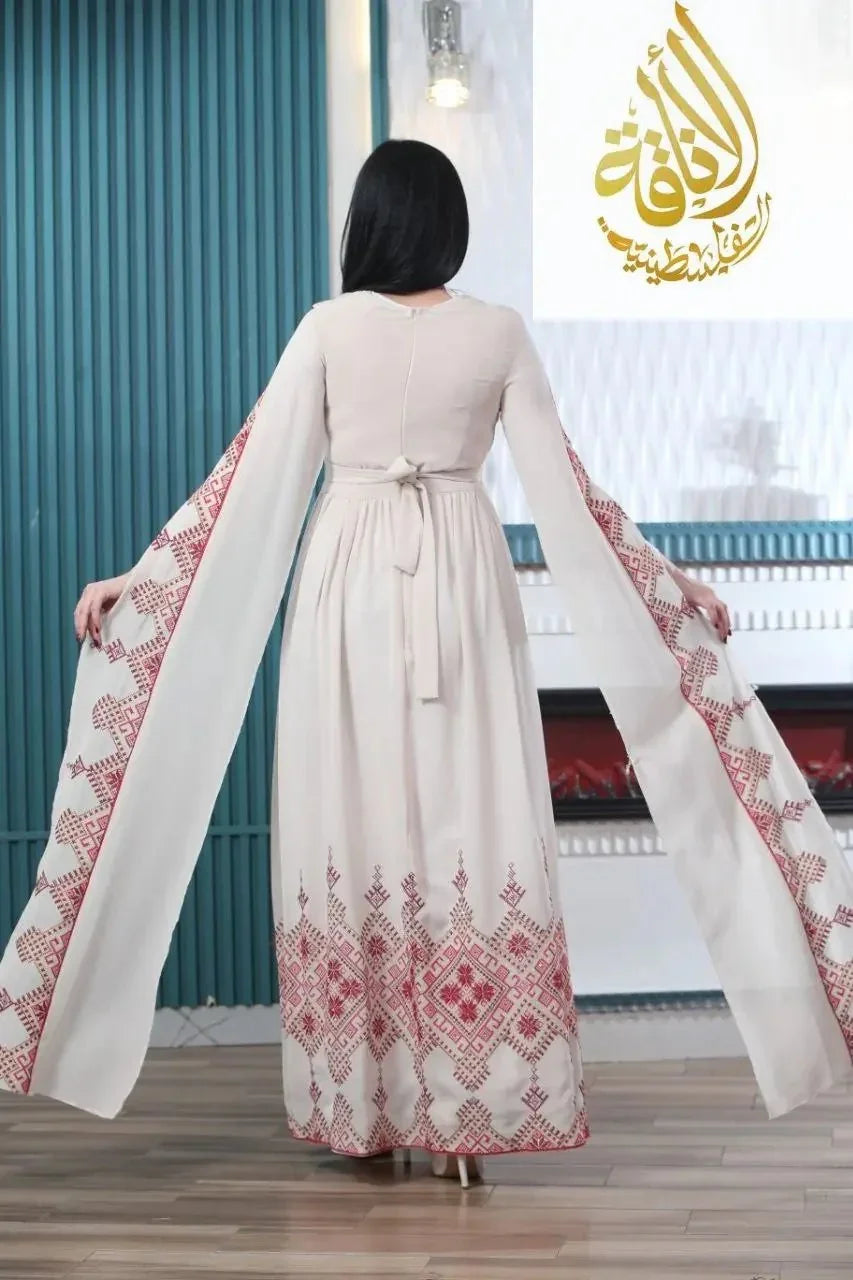 Back view of modern embroidered Palestinian dress by Palestinian Elegance with long sleeves and intricate red patterns