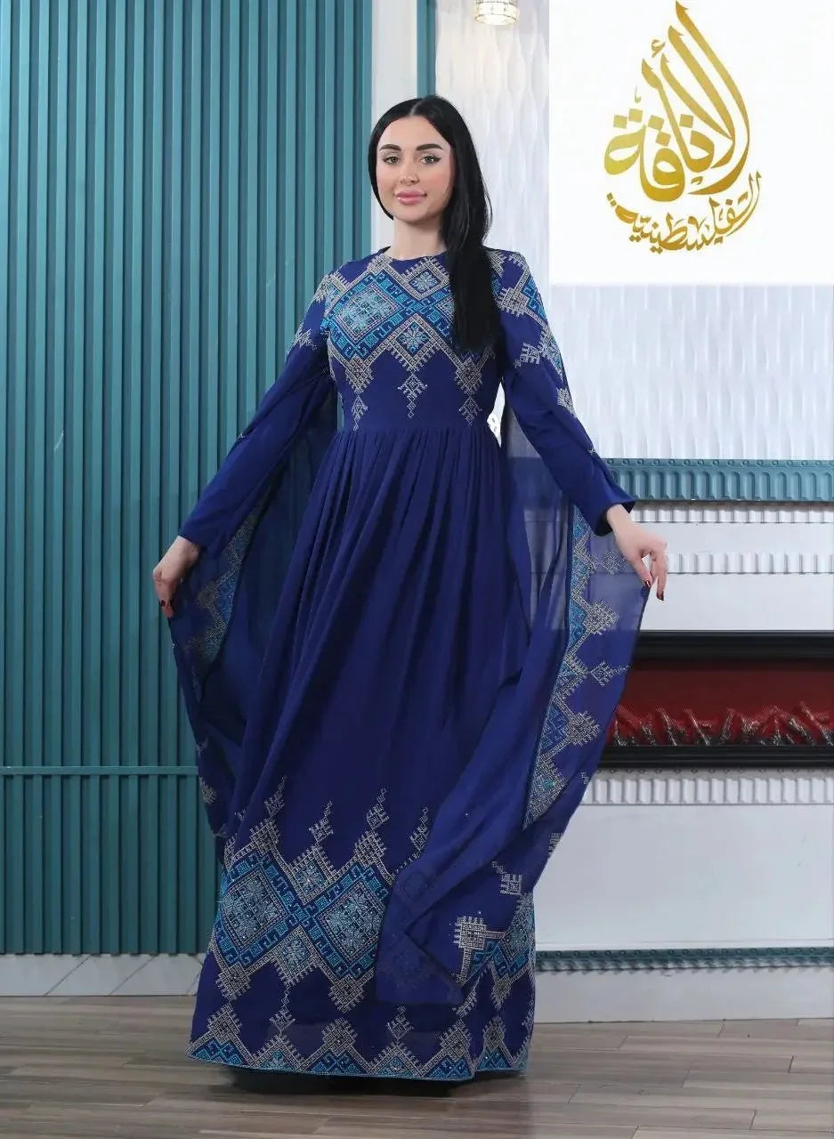 Woman wearing a modern embroidered Palestinian dress in blue with detailed geometric embroidery by Palestinian Elegance