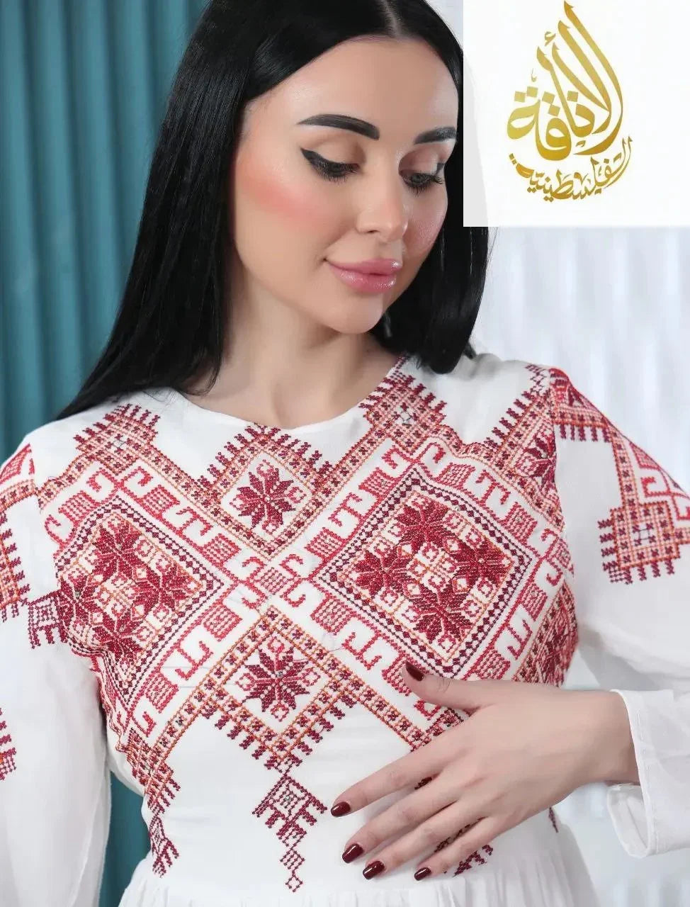 Modern embroidered Palestinian dress with intricate red and white embroidery worn by woman from Palestinian Elegance