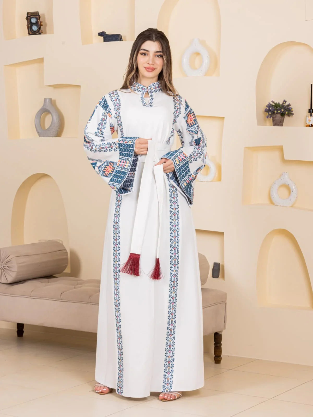 Asala Embroidered Thoub Palestinian Elegance white ankle length thobe with blue geometric embroidery and red tassel belt